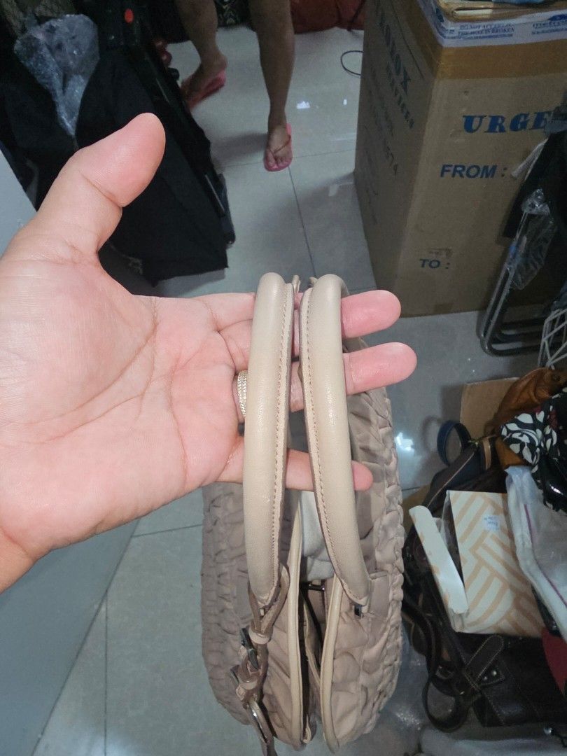 Prada Nappa Gaufre leather tote bag (Category: Luxury Bags & Wallets) located in Las Pinas. Submitted by whimsyandwonder (Listing ID 1417236637, Image 3). Description: - Beige Prada handbag - Ruched detailing - Dual top handles - Rectangular shape - Prada logo on front - Metal feet at base - with sling.