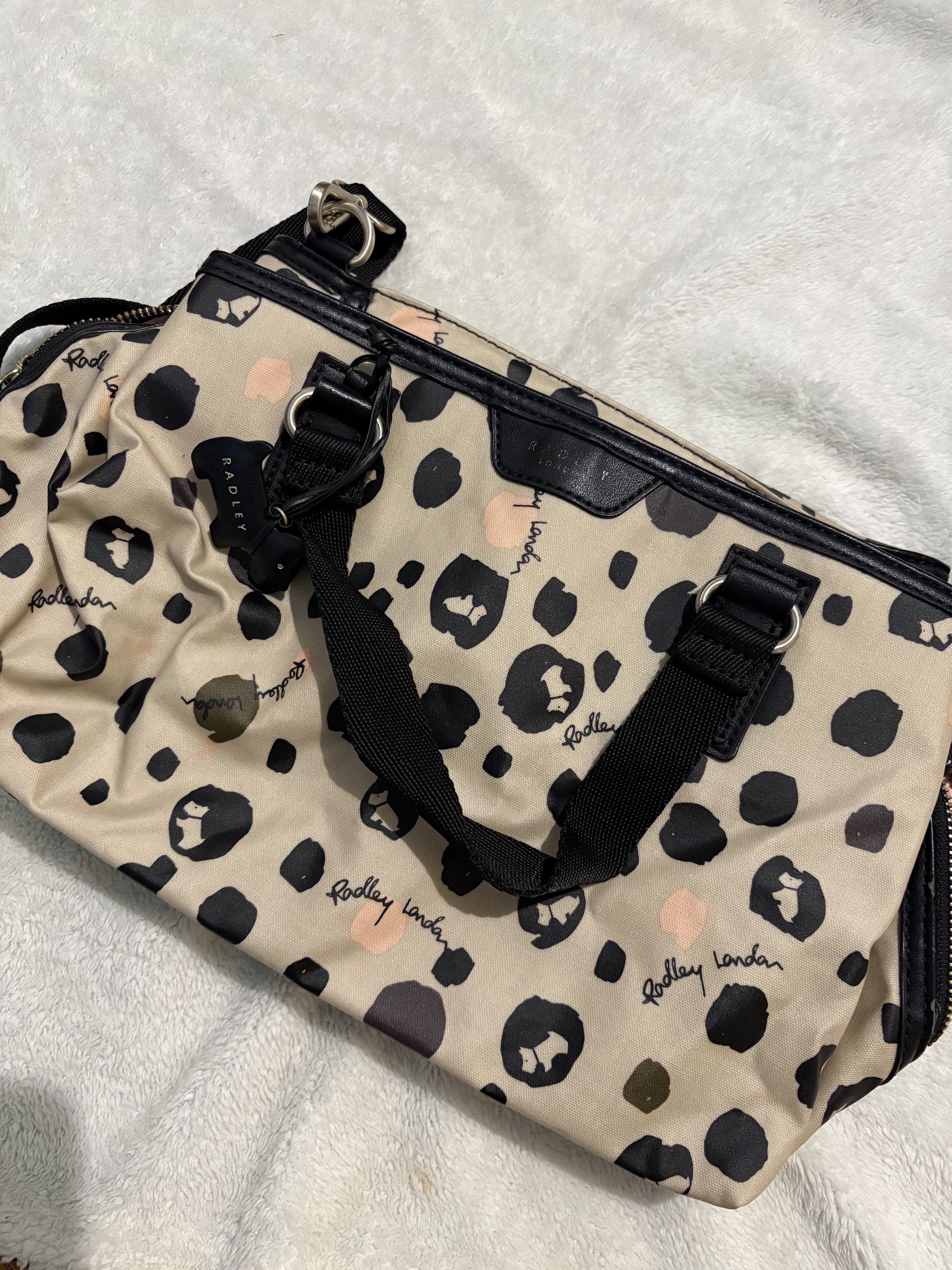Radley London Leopard Print Handbag (Category: Luxury Bags & Wallets) located in Quezon City. Submitted by tonipatootie (Listing ID 1417296598, Image 1). Description: DECLUTTERING - Radley London handbag with a stylish leopard print. - Features a top handle and a detachable shoulder strap. - Offers versatile carrying options. - Interior includes multiple compartments. - Secure zip closure. - Comes with the iconic Radley dog charm. - Light pink in
