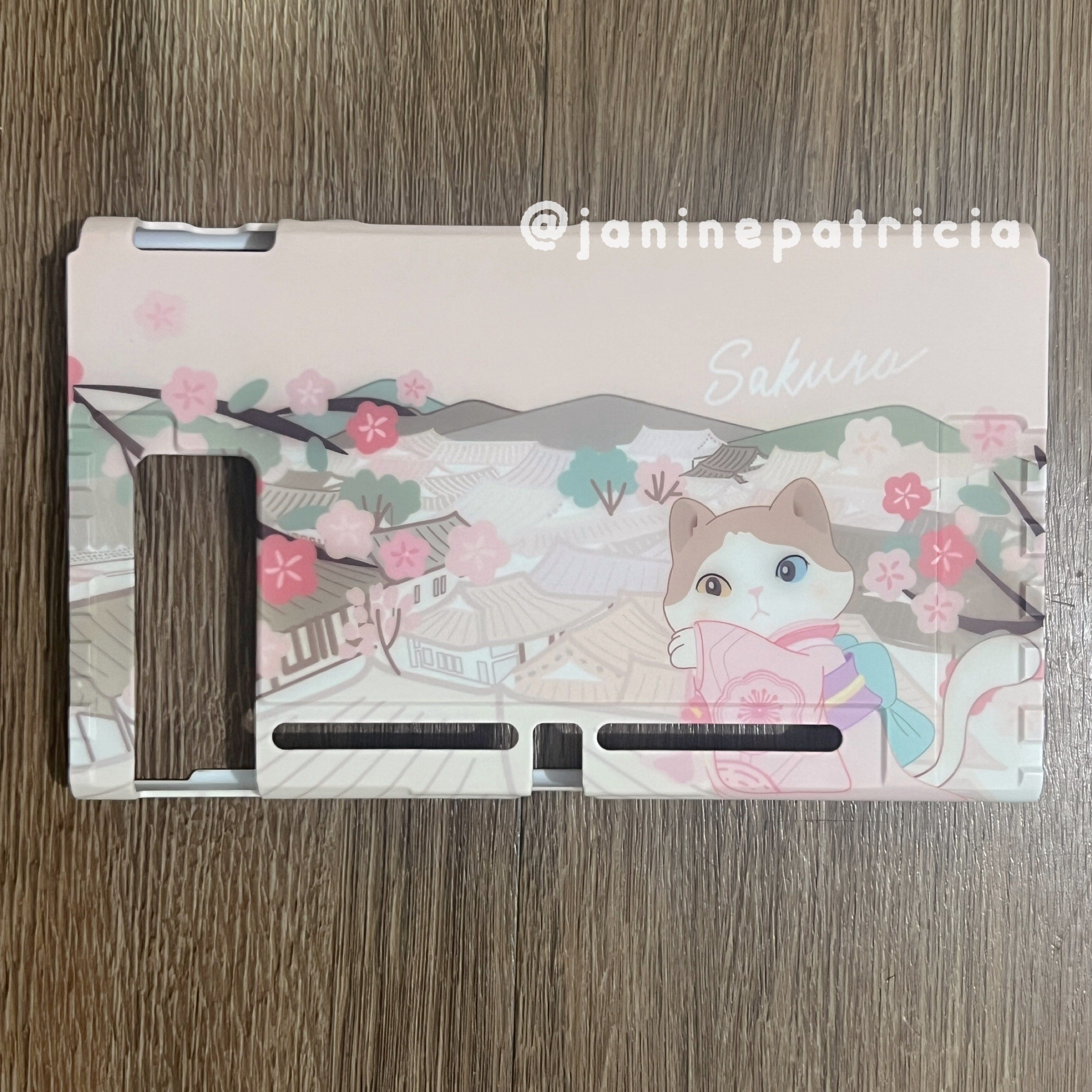 Sakura Cat Nintendo Switch Case (Category: Cases & Covers) located in Pasay City. Submitted by janinepatricia (Listing ID 1417368431, Image 3). Description: Preloved Nintendo Switch V1/V2 Case. Still in good condition. Bought from Paw Diary. Free preloved cat thumb grips. Not compatible with Nintendo Switch 2/OLED/Lite..