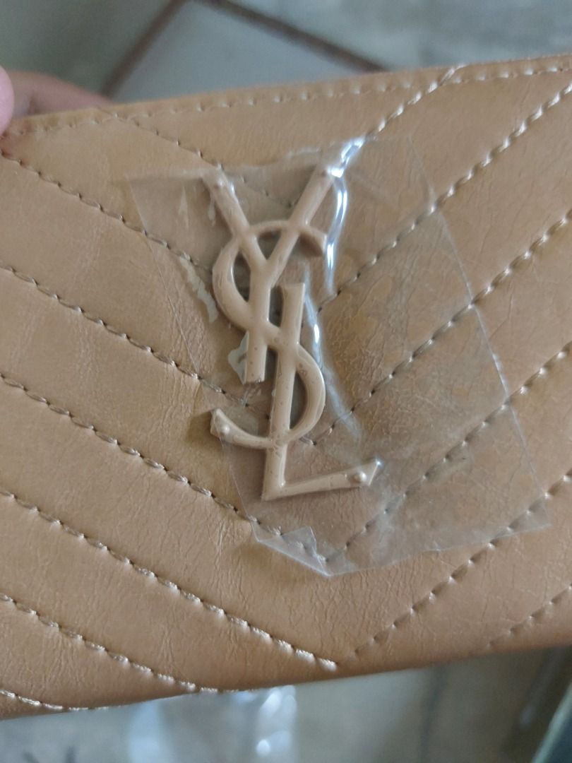 YSL Beige Wallet (Category: Luxury Bags & Wallets) located in Malaybalay. Submitted by mags_sofia (Listing ID 1417344932, Image 3). Description: - Brand new beige YSL wallet - Gold-colored zipper with plastic protector - Features the iconic YSL logo - Elegant quilted design - Comes with original box.