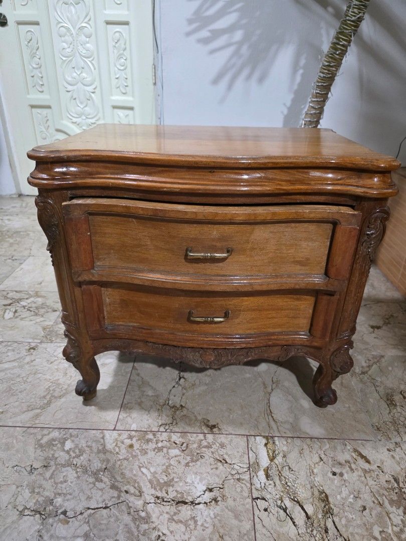 Bed Side Wooden Cabinet with Drawers (Category: Shelves, Cabinets & Racks) located in Mandaluyong City. Submitted by jhaysellshere (Listing ID 1417589144, Image 1). Description: European style bed side cabinet with two drawers. Features ornate carvings, brass handles, and a warm wood finish. Sturdy and well-crafted. Material is heavy.