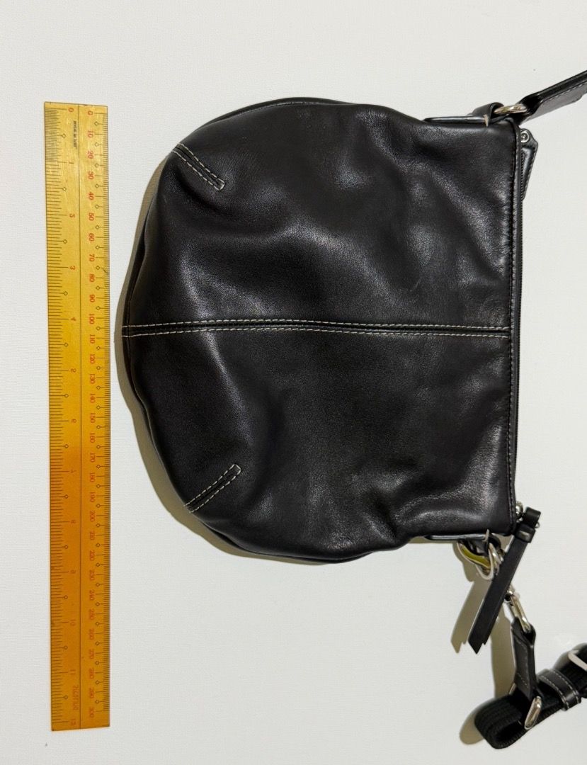 Coach Black Leather Crossbody Bag (Category: Luxury Bags & Wallets) located in Santa Rosa. Submitted by biancamarie0404 (Listing ID 1417479333, Image 2). Description: Black leather crossbody bag from Coach. Features a zip closure and a long, adjustable strap. Includes a Coach hangtag. The bag has white stitching details and silver-tone hardware. The bag has a rounded shape..