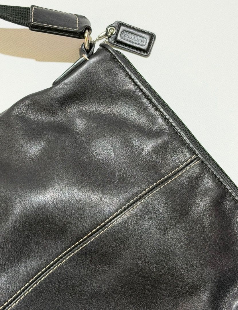 Coach Black Leather Crossbody Bag (Category: Luxury Bags & Wallets) located in Santa Rosa. Submitted by biancamarie0404 (Listing ID 1417479333, Image 3). Description: Black leather crossbody bag from Coach. Features a zip closure and a long, adjustable strap. Includes a Coach hangtag. The bag has white stitching details and silver-tone hardware. The bag has a rounded shape..
