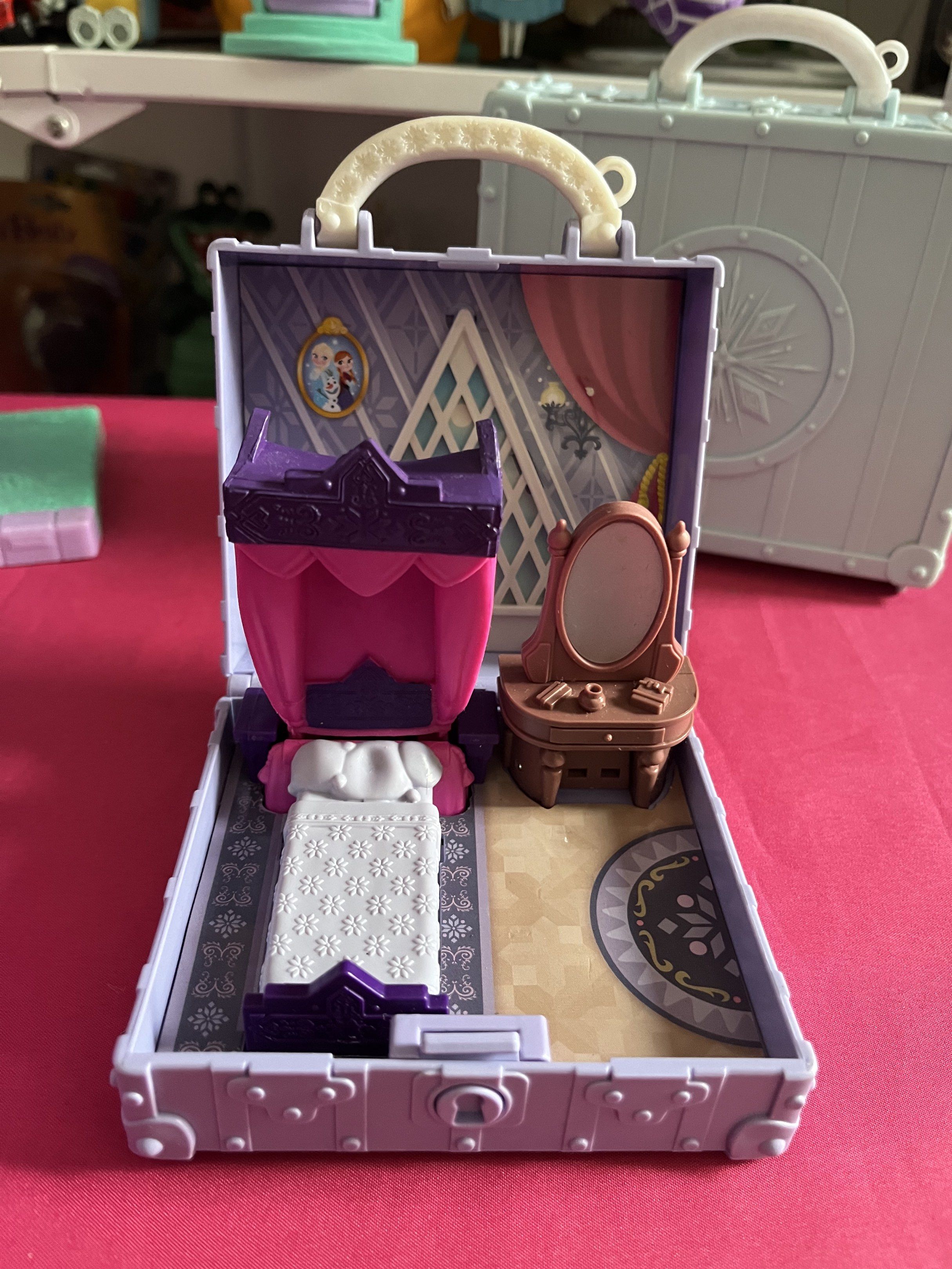 Disney Frozen Suitcase Playset (Category: Kids Toys) located in Calamba. Submitted by thepinkpicksee (Listing ID 1417484351, Image 2). Description: - Disney Frozen playset - Features a suitcase design with snowflake emblem - Includes a bedroom scene: bed, vanity, and framed picture - Miniature toy for imaginative play - Suitcase has a handle for easy carrying.