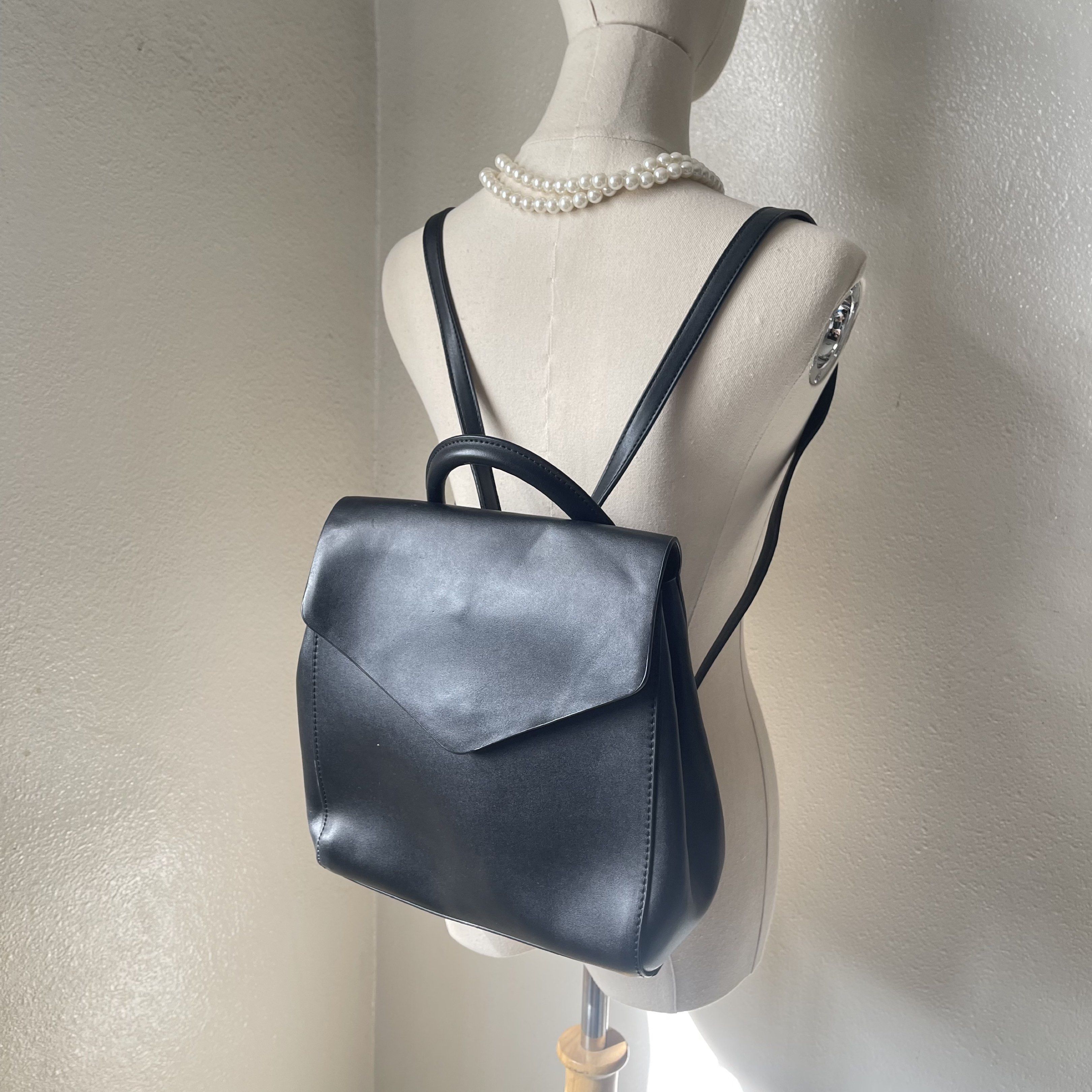 Mango Black Backpack (Category: Backpacks) located in Norzagaray. Submitted by rss13 (Listing ID 1417471955, Image 1). Description: - Black Mango backpack - Flap closure - Top handle - Adjustable shoulder straps - Interior pocket - Made of smooth, leather-like material - Mango brand visible inside.