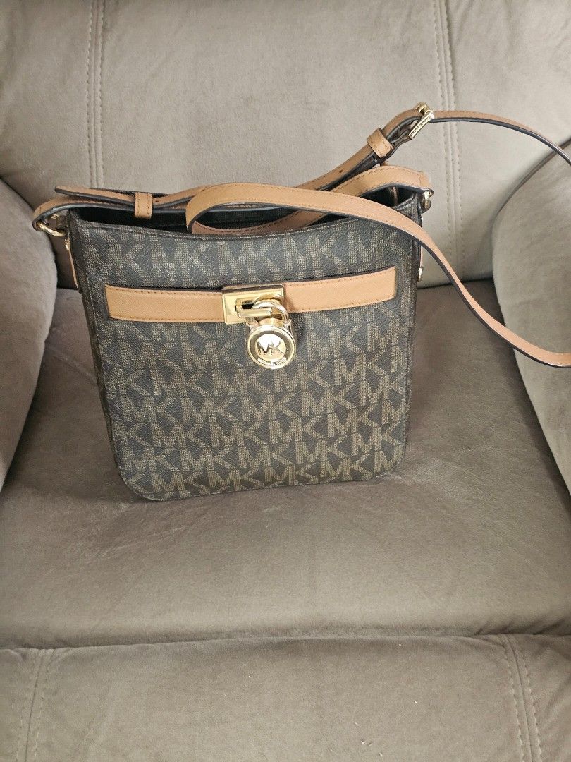 Michael Kors Crossbody Bag (Category: Luxury Bags & Wallets) located in Caloocan City. Submitted by cecilleuy648-00384 (Listing ID 1417453970, Image 2). Description: - Michael Kors crossbody bag - Brown monogram pattern - Tan strap and accents - Gold-tone lock closure - Adjustable strap for shoulder or crossbody wear - Compact design - Ideal for everyday use.