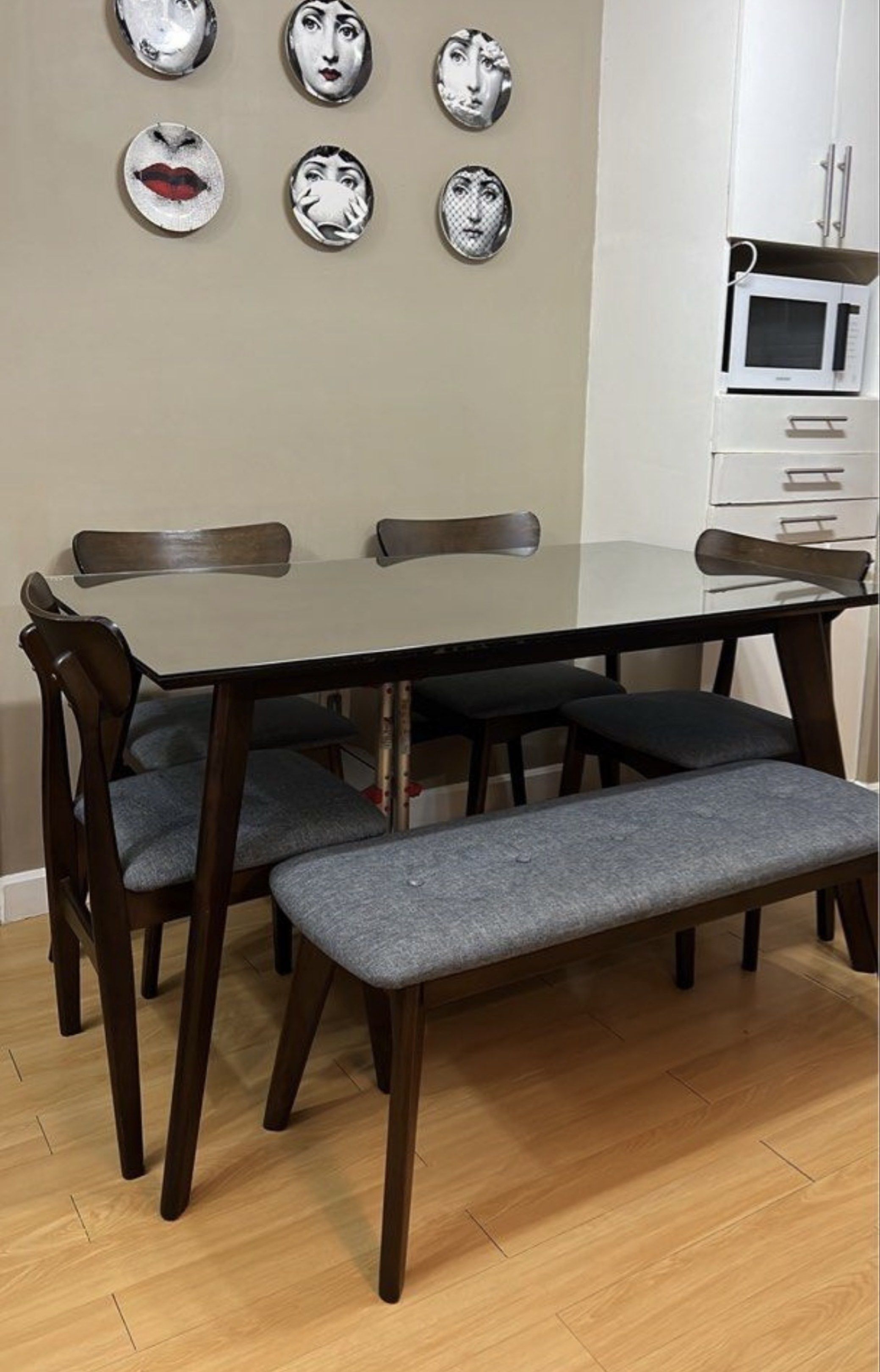 Mid-Century Modern Dining Table Set (Category: Tables & Sets) located in Manila. Submitted by epn_sale (Listing ID 1417502724, Image 1). Description: - Mid-century modern dining set - Includes: Rectangular table, 4 chairs, and bench - Table: Dark wood finish with glass top - Chairs and bench: Gray upholstered seats - Seats up to 6 people - glass top worth 8k sold separately but will give it for free - no scratches, no bumps, no smell .