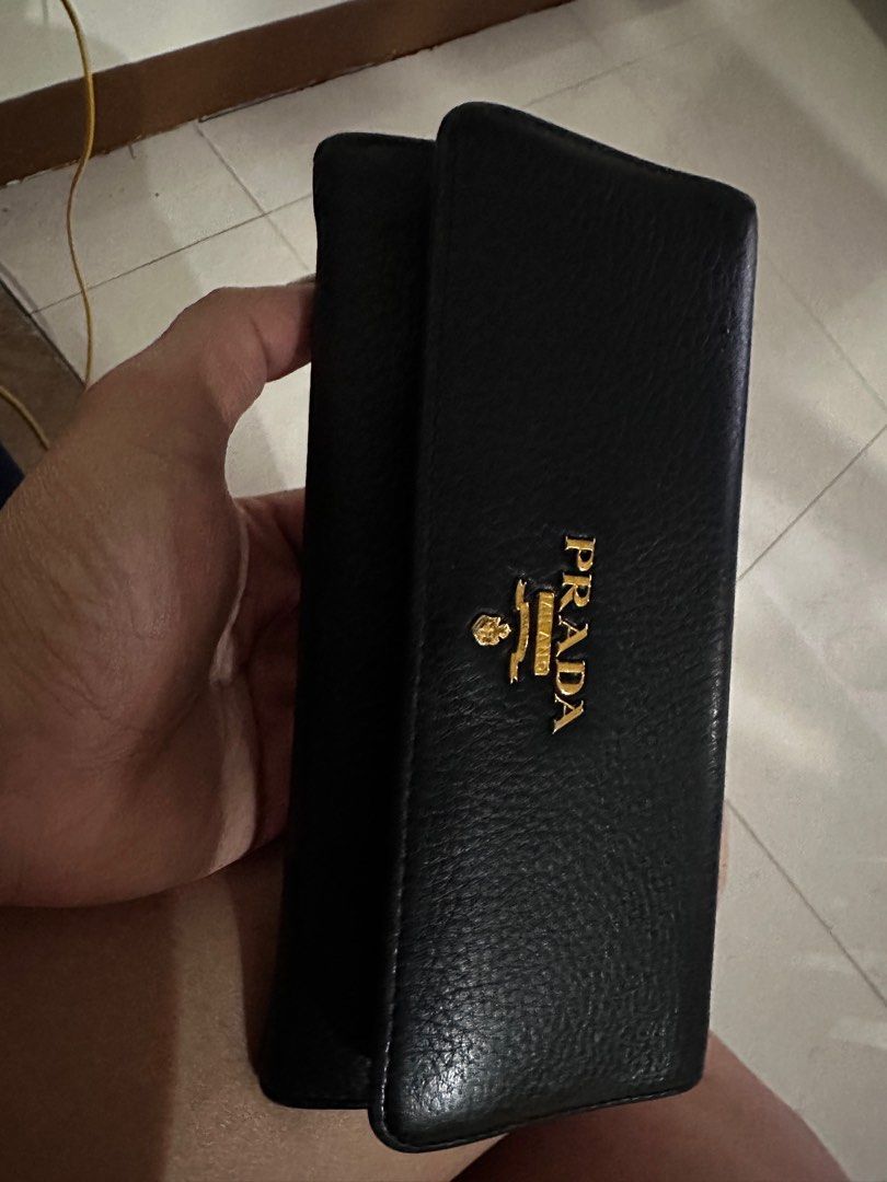 Prada Leather Wallet (Category: Luxury Bags & Wallets) located in Taguig. Submitted by shebree (Listing ID 1413697282, Image 1). Description: - Authentic Prada wallet - Gold Prada logo - Long, bi-fold style - Includes original box - Includes authenticity card for Prada -Wear may include creasing, edge wear, and surface marks -No major rips or defects affecting functionality -Please review all photos carefully and feel free to ask for additional i