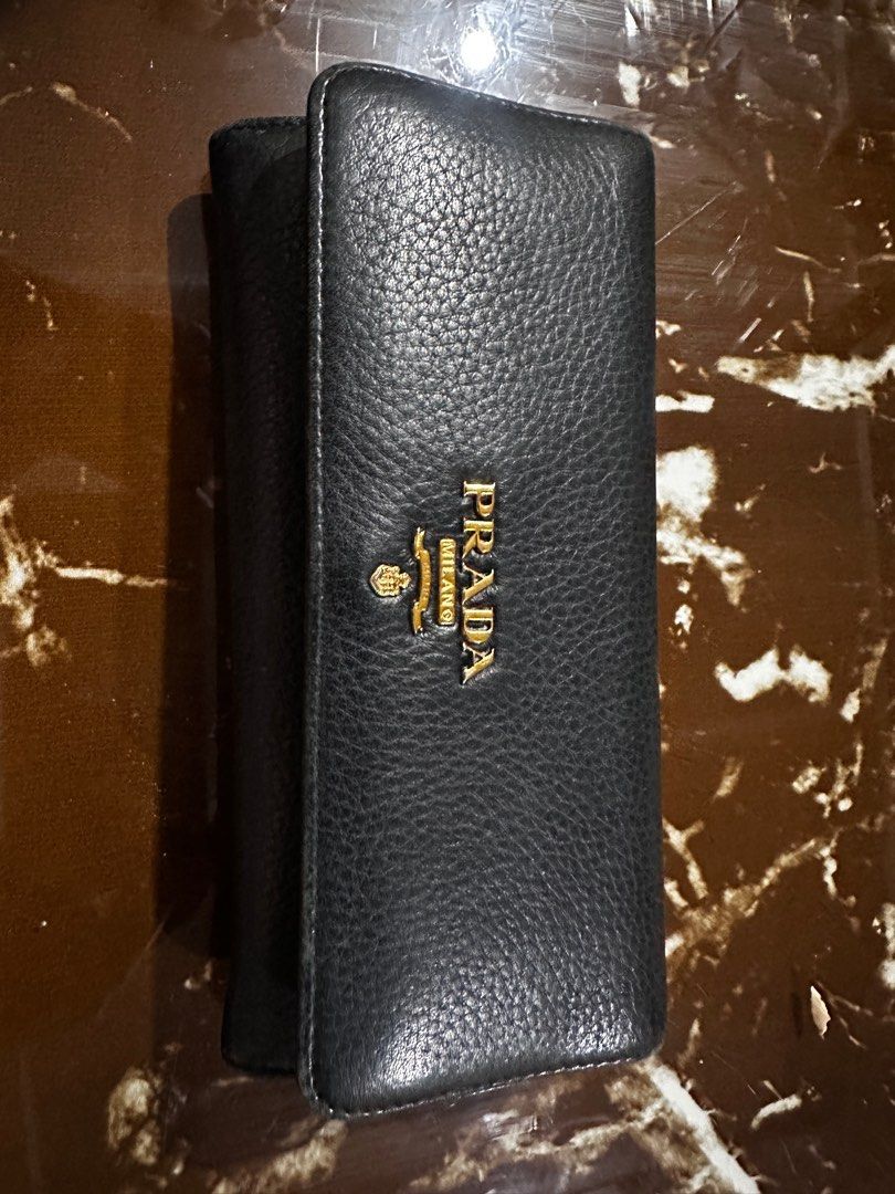 Prada Leather Wallet (Category: Luxury Bags & Wallets) located in Taguig. Submitted by shebree (Listing ID 1413697282, Image 3). Description: - Authentic Prada wallet - Gold Prada logo - Long, bi-fold style - Includes original box - Includes authenticity card for Prada -Wear may include creasing, edge wear, and surface marks -No major rips or defects affecting functionality -Please review all photos carefully and feel free to ask for additional i