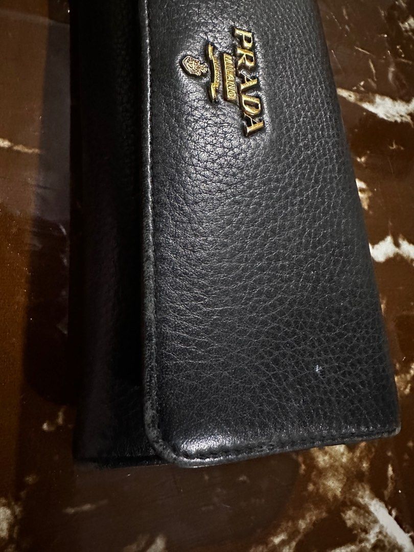 Prada Leather Wallet (Category: Luxury Bags & Wallets) located in Taguig. Submitted by shebree (Listing ID 1413697282, Image 2). Description: - Authentic Prada wallet - Gold Prada logo - Long, bi-fold style - Includes original box - Includes authenticity card for Prada -Wear may include creasing, edge wear, and surface marks -No major rips or defects affecting functionality -Please review all photos carefully and feel free to ask for additional i
