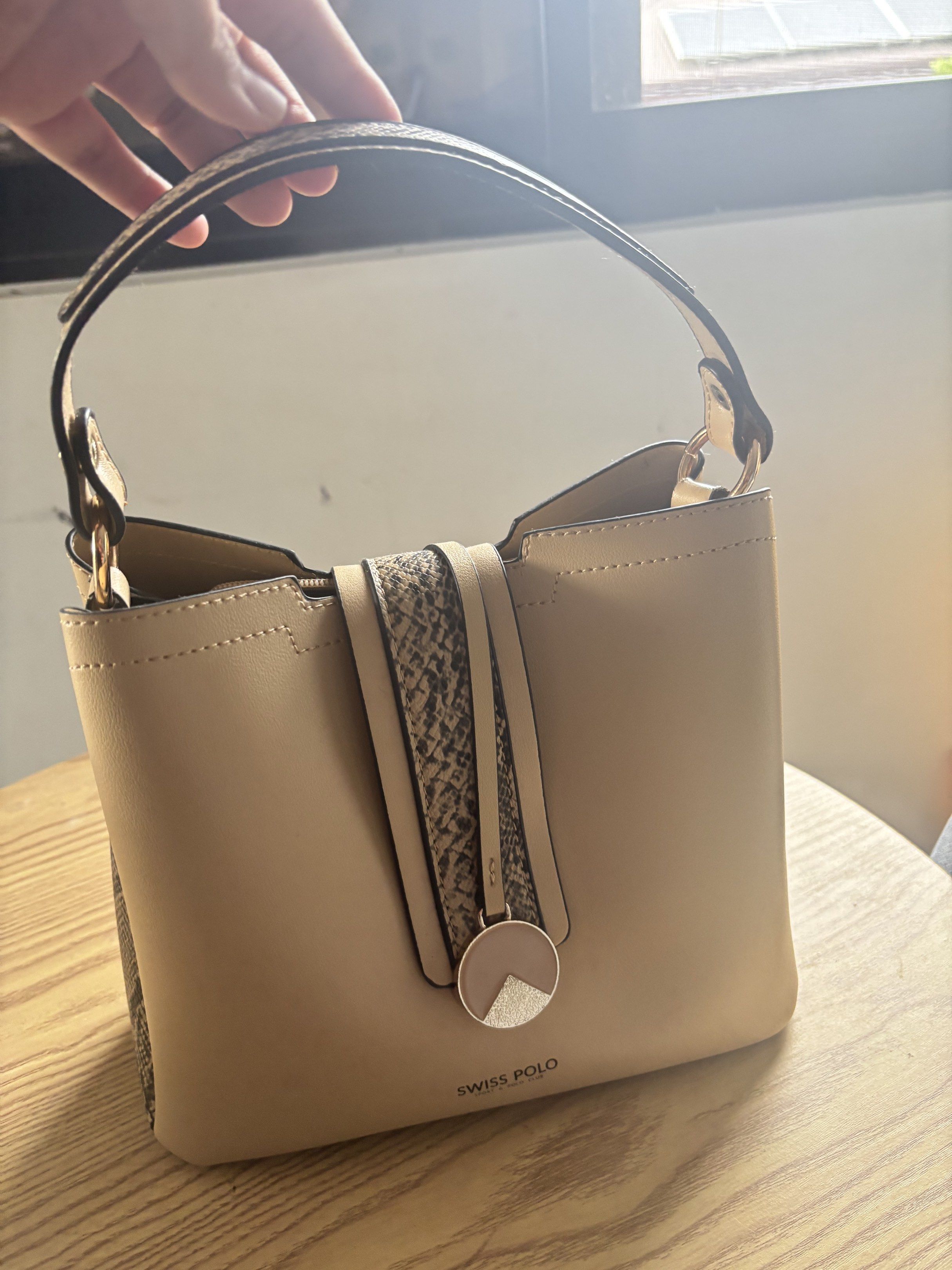 Swiss Polo Handbag (Category: Luxury Bags & Wallets) located in Bulacan. Submitted by mreyes21 (Listing ID 1417487239, Image 1). Description: - Swiss Polo handbag - Beige exterior with snakeskin pattern - Top handle - Includes a small, circular charm - Structured shape - Zippered interior compartment - Magnetic closure.