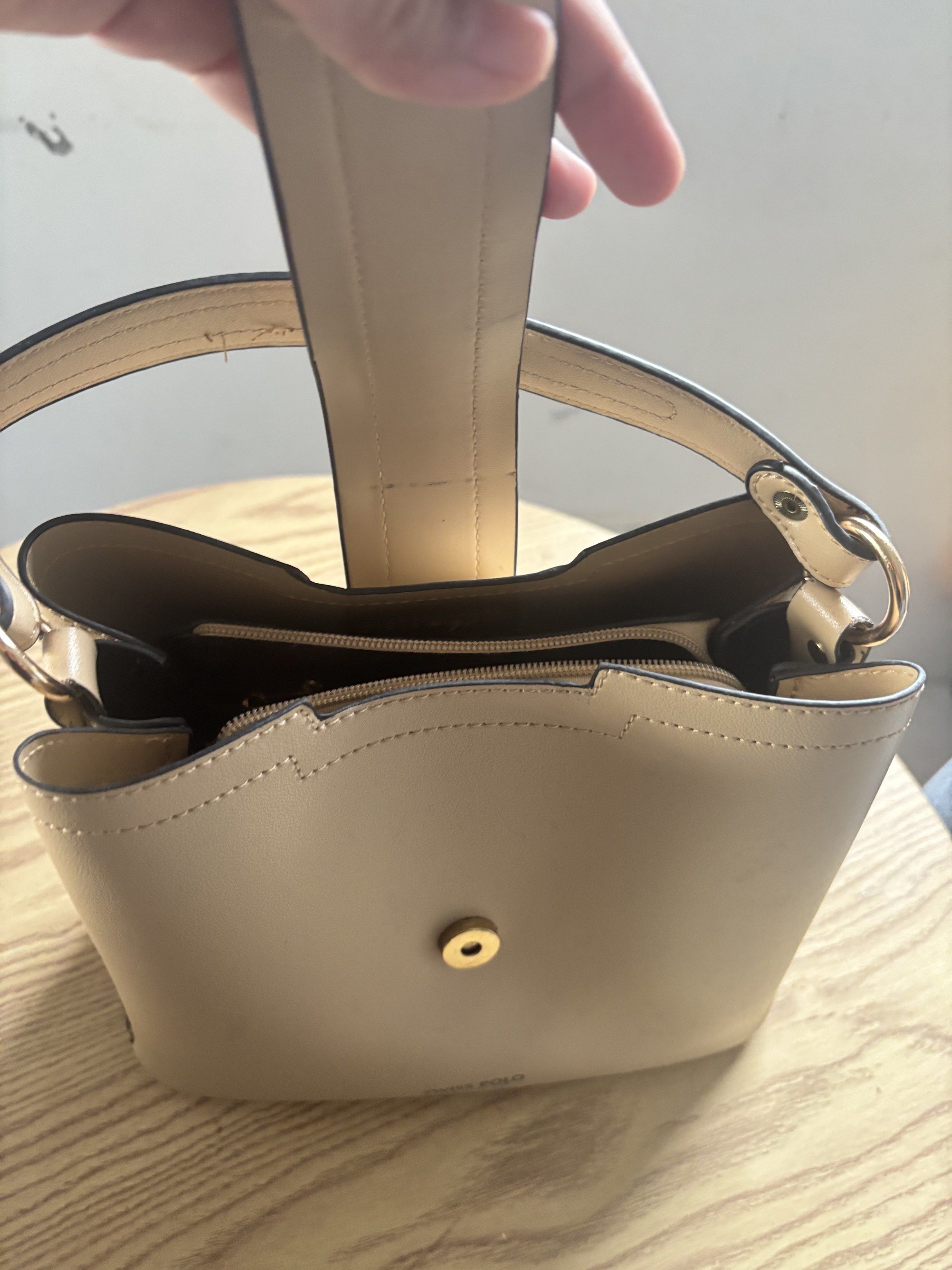 Swiss Polo Handbag (Category: Luxury Bags & Wallets) located in Bulacan. Submitted by mreyes21 (Listing ID 1417487239, Image 2). Description: - Swiss Polo handbag - Beige exterior with snakeskin pattern - Top handle - Includes a small, circular charm - Structured shape - Zippered interior compartment - Magnetic closure.