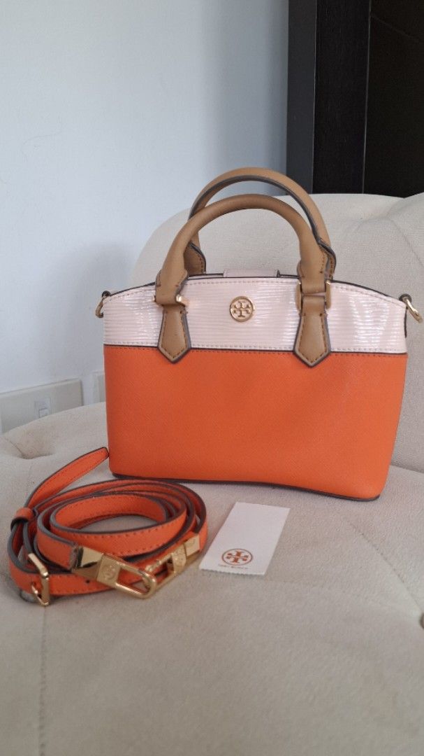 Tory Burch Satchel Bag with Strap (Category: Luxury Bags & Wallets) located in Paranaque City. Submitted by november_lounge (Listing ID 1417440965, Image 1). Description: Selling really low (please check all photos) - Tory Burch satchel bag - Color: Orange and cream - Detachable orange strap with gold-tone hardware - Top handle - Gold Tory Burch logo - Interior: Light pink - Zipper closure - Includes tag -Mode of payment: Gcash or bank transfer o