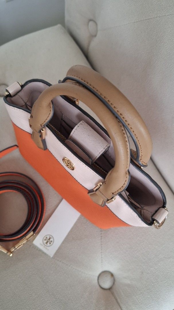 Tory Burch Satchel Bag with Strap (Category: Luxury Bags & Wallets) located in Paranaque City. Submitted by november_lounge (Listing ID 1417440965, Image 3). Description: Selling really low (please check all photos) - Tory Burch satchel bag - Color: Orange and cream - Detachable orange strap with gold-tone hardware - Top handle - Gold Tory Burch logo - Interior: Light pink - Zipper closure - Includes tag -Mode of payment: Gcash or bank transfer o