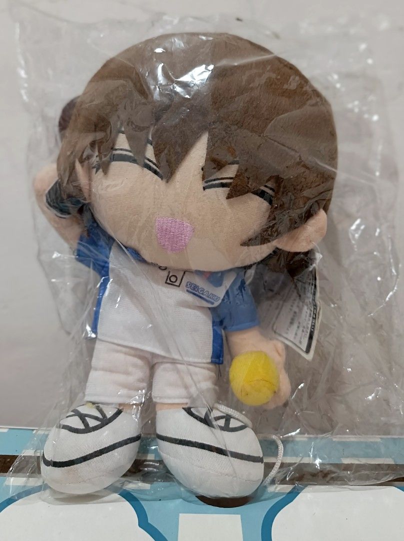Anime Plush Doll (Category: Plushies & Soft Toys) located in Baliuag. Submitted by supremo1992 (Listing ID 1417742863, Image 1). Description: - Brand new plush doll - Still in original packaging - Features a character in a tennis outfit - Brown hair and pink nose - Holding a yellow ball - White and blue outfit - White shoes.