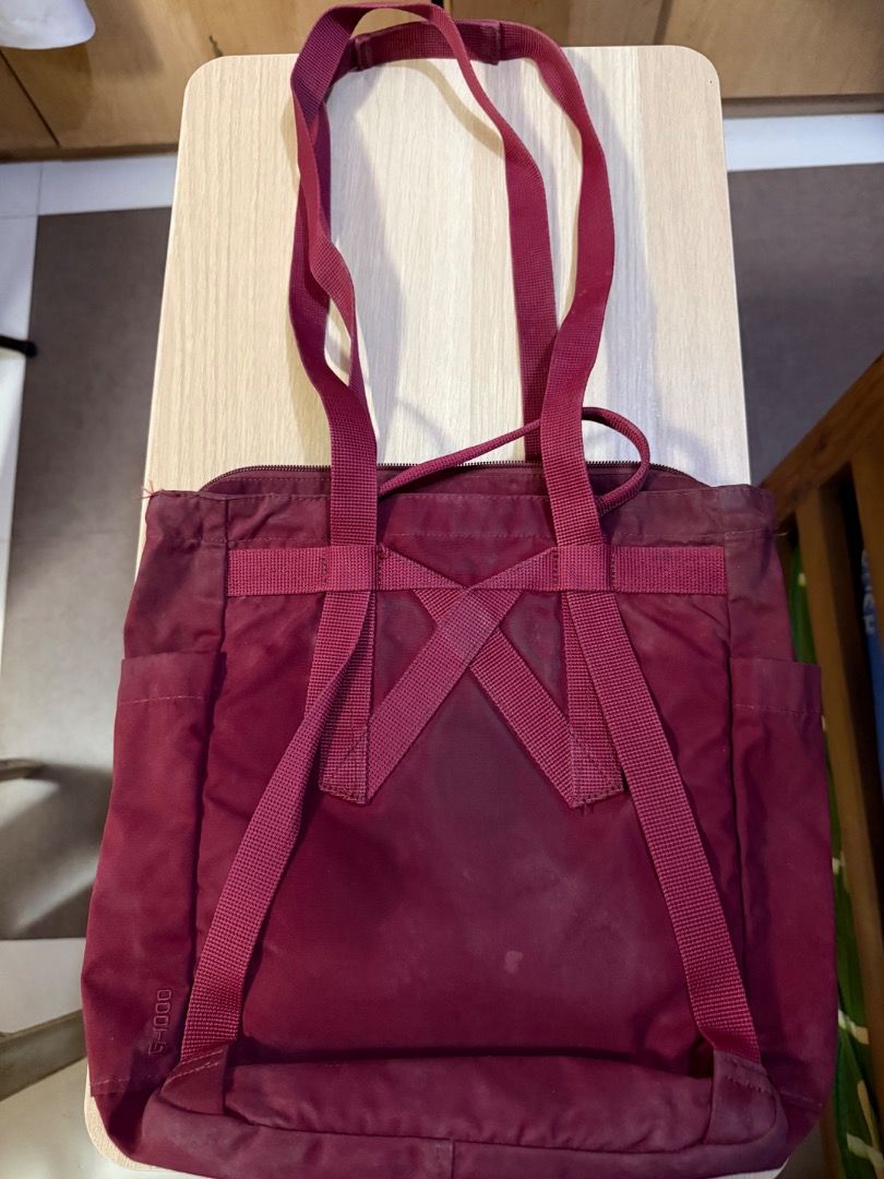 Fjallraven Kanken Totepack - Ox Red (Category: Tote Bags) located in Manila. Submitted by rencied (Listing ID 1417769972, Image 2). Description: Fjallraven Kanken Totepack in ox red. Features a main compartment with a zipper closure, front pocket, and side pockets. It has both tote handles and adjustable shoulder straps. The bag has the Fjallraven logo on the front. The back has the straps that can be used as backpack straps..