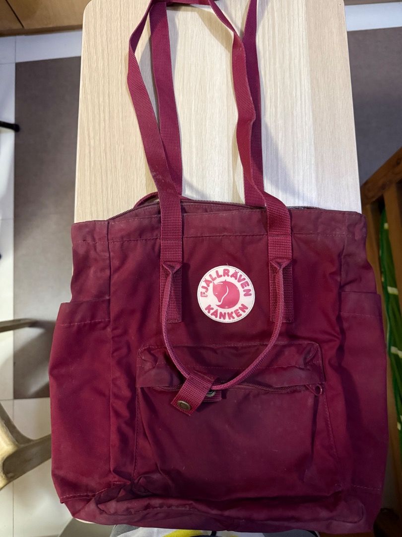 Fjallraven Kanken Totepack - Ox Red (Category: Tote Bags) located in Manila. Submitted by rencied (Listing ID 1417769972, Image 1). Description: Fjallraven Kanken Totepack in ox red. Features a main compartment with a zipper closure, front pocket, and side pockets. It has both tote handles and adjustable shoulder straps. The bag has the Fjallraven logo on the front. The back has the straps that can be used as backpack straps..