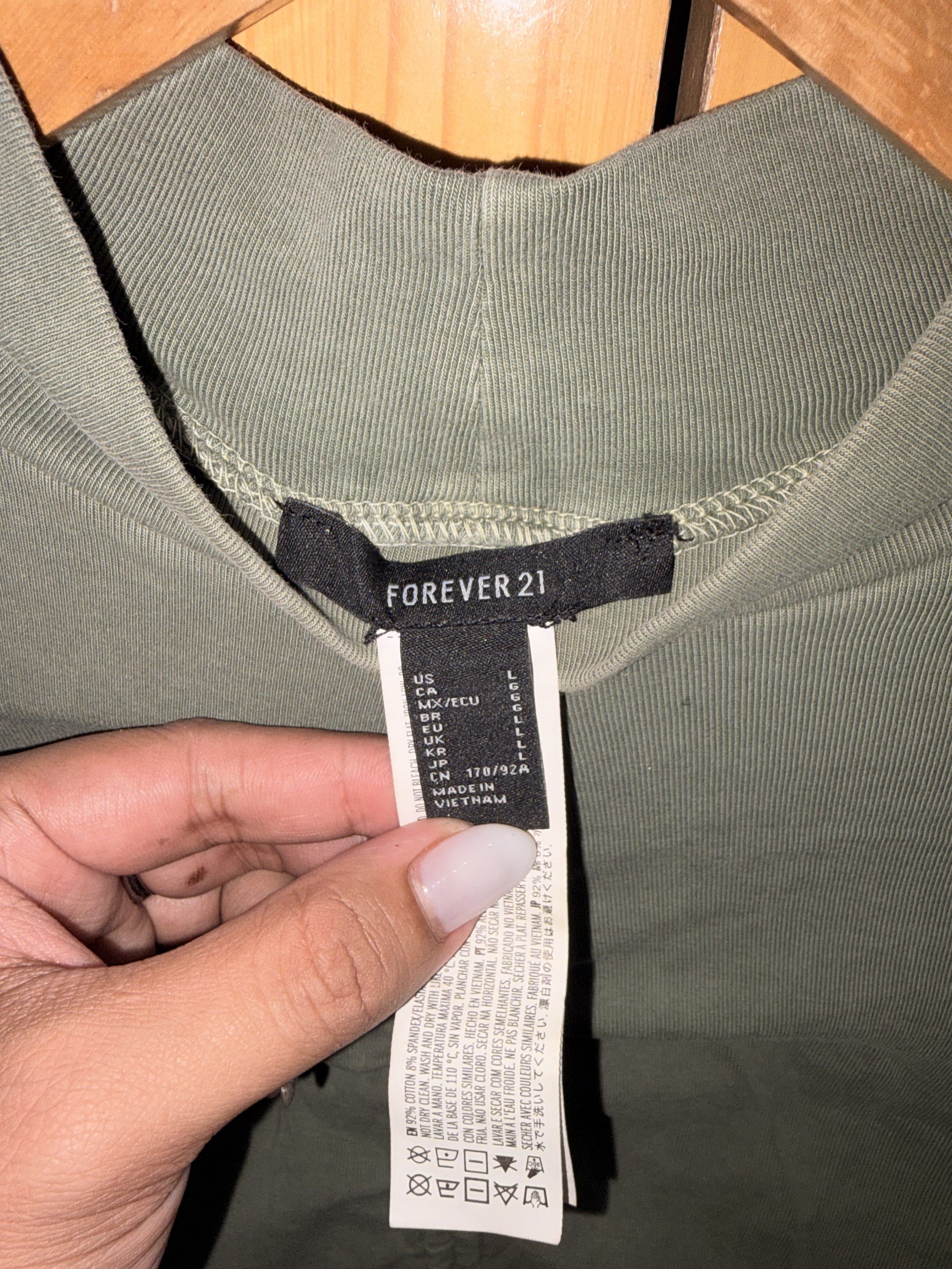 Forever 21 Olive Green Ruched Top (Category: Blouses) located in Manila. Submitted by ciiii1 (Listing ID 1417735731, Image 3). Description: Olive green long-sleeved top from Forever 21. Features a mock neck and ruched detailing down the front. The top is a cropped length. Size L. Made in Vietnam..