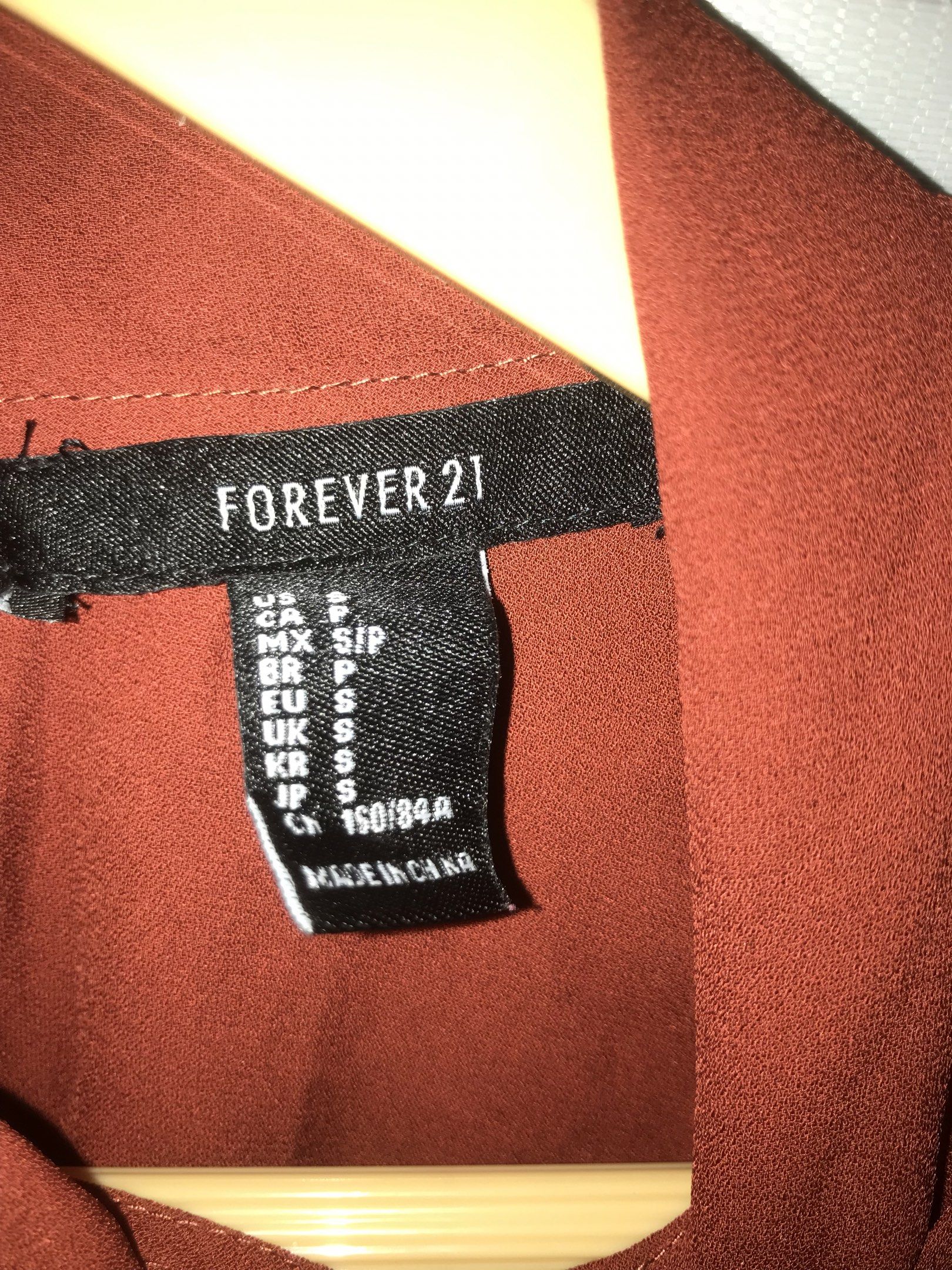 Forever 21 Rust Blouse (Category: Blouses) located in Makati City. Submitted by closet.declutterph (Listing ID 1417781591, Image 2). Description: - Forever 21 blouse - Color: Rust - Features: - Mock neck with tie - Long sleeves - Buttoned cuffs - Fit: Relaxed - Size: Small (S).