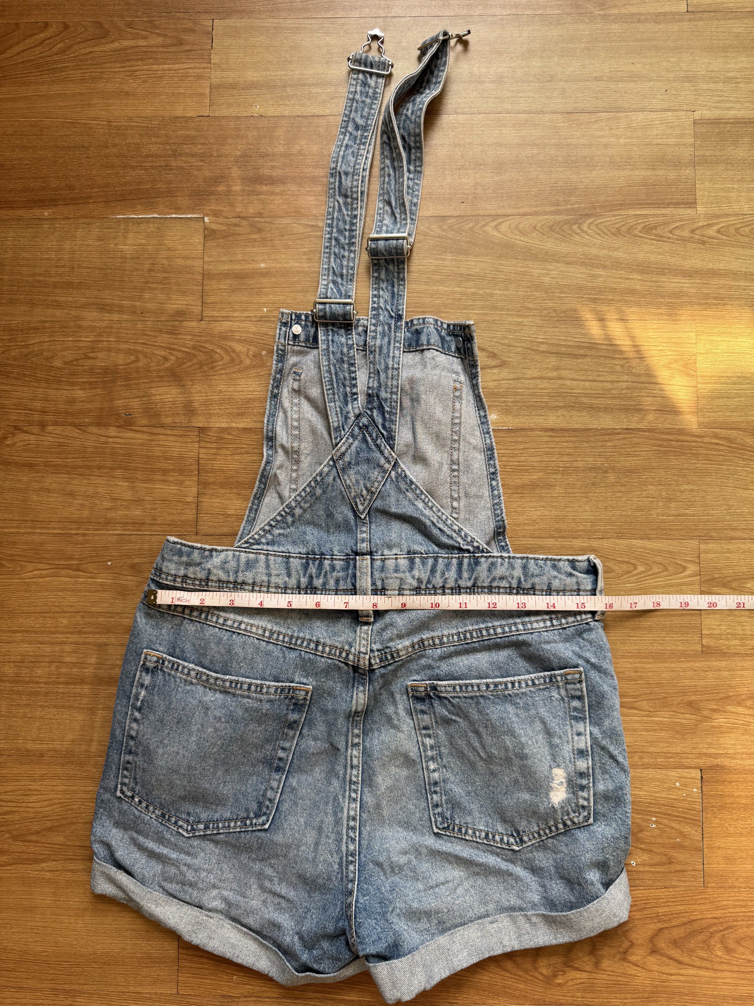 H&M Denim Overalls Shorts (Category: Jumpsuits) located in Manila. Submitted by obach (Listing ID 1417734130, Image 3). Description: - H&M denim overalls shorts - Light blue wash with distressed details - Adjustable straps - Multiple pockets - Rolled hem - Size: EUR 36, US 4, CA 4, CN 165/68A - Waist: Approximately 15 inches across - Made in Bangladesh.