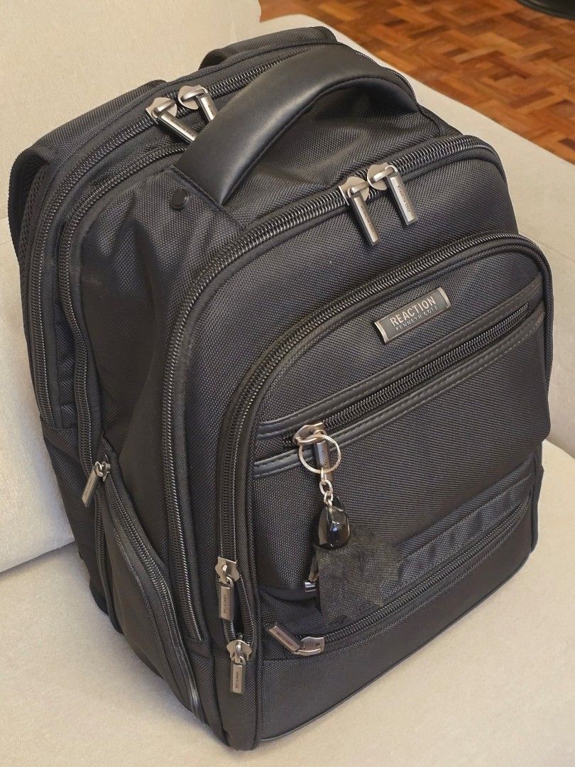 Kenneth Cole Reaction Black Backpack (Category: Backpacks) located in Makati City. Submitted by nelsonl4 (Listing ID 1417690318, Image 2). Description: - Kenneth Cole Reaction backpack - Black, textured fabric. blue inside - Multiple compartments and pockets - Dedicated laptop compartment - Zippered sections for organization - Padded handle and adjustable straps - ordered - Silver-toned hardware.
