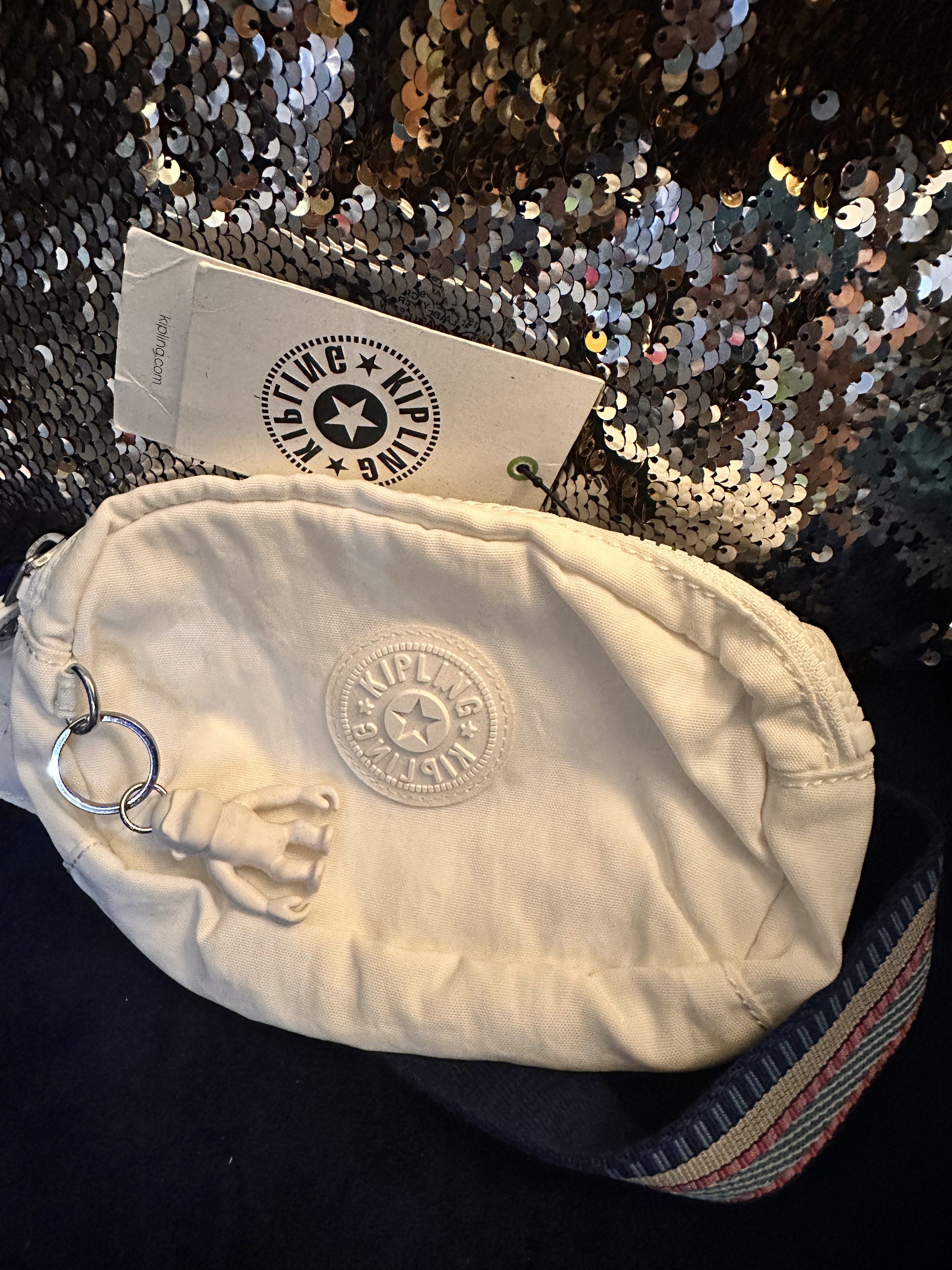 SALE!!! Kipling White Sling Bag (Category: Cross-body Bags) located in Manila. Submitted by youngdolphin-00c7ca (Listing ID 1417791274, Image 1). Description: - Kipling sling bag - White exterior and interior - Zip closure - Patterned strap - Kipling logo detail - Includes a small keychain .