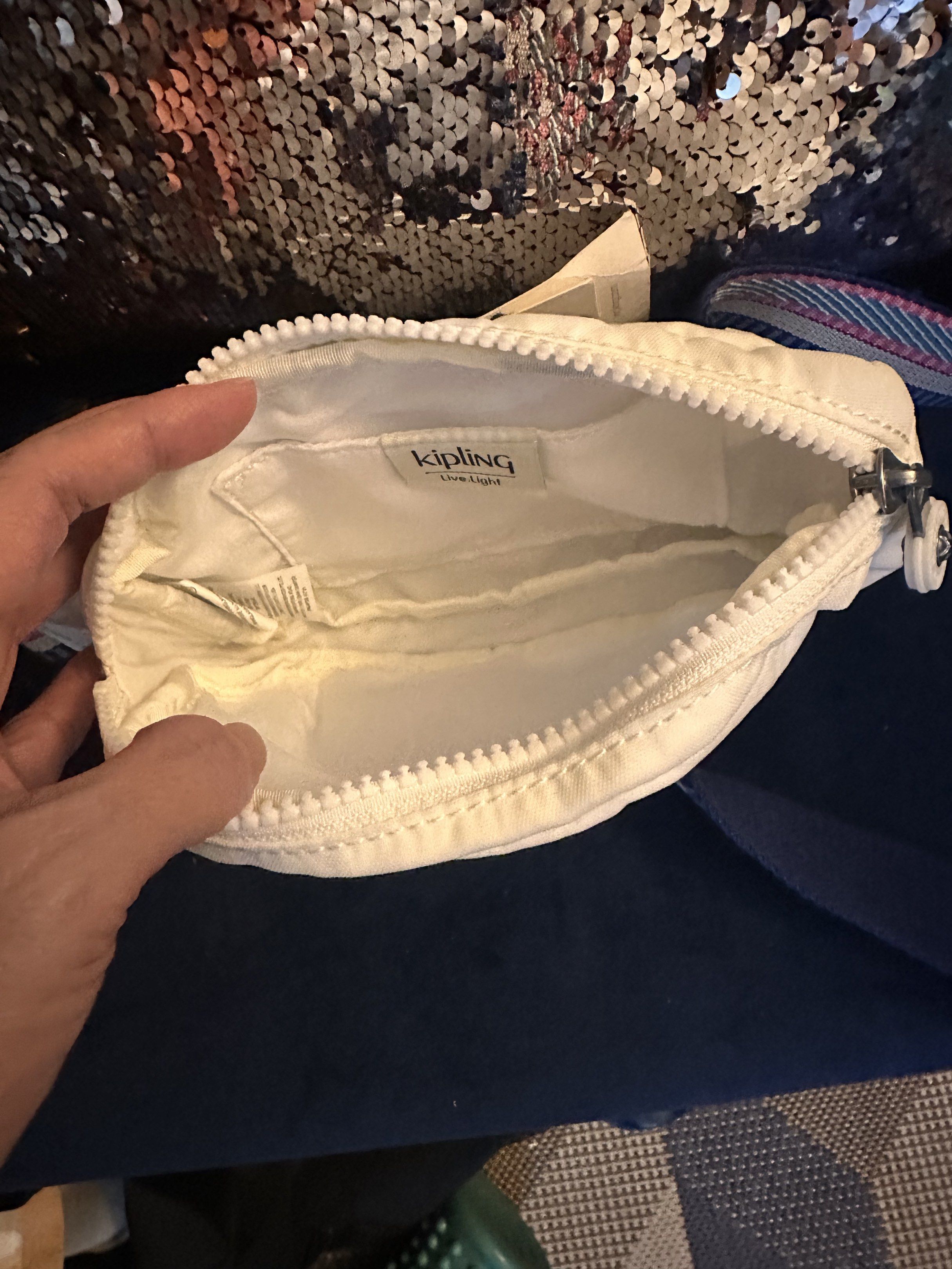 SALE!!! Kipling White Sling Bag (Category: Cross-body Bags) located in Manila. Submitted by youngdolphin-00c7ca (Listing ID 1417791274, Image 3). Description: - Kipling sling bag - White exterior and interior - Zip closure - Patterned strap - Kipling logo detail - Includes a small keychain .