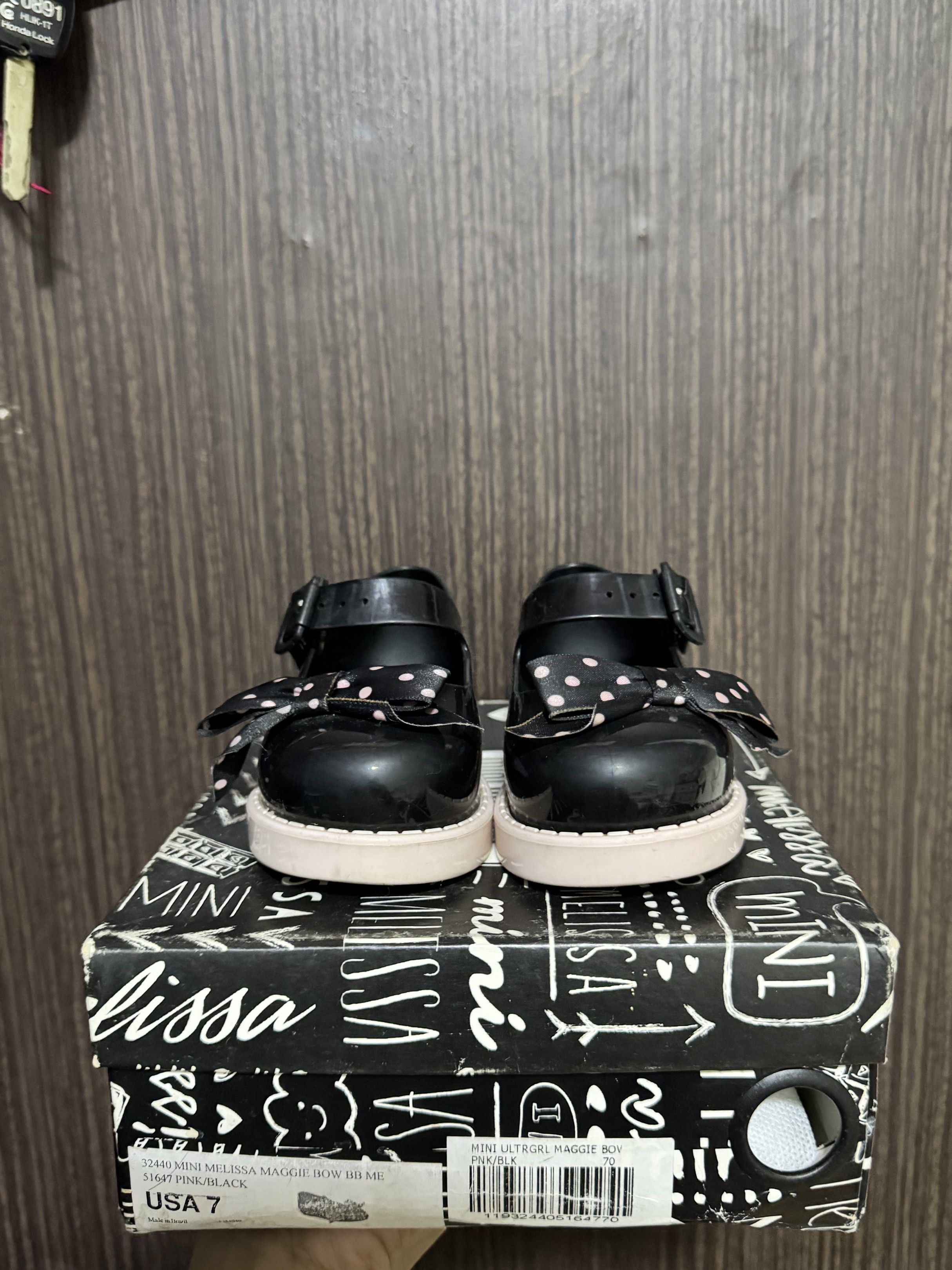 Mini Melissa Maggie Bow BB Shoes - Black (Category: Babies & Kids Fashion) located in Paranaque City. Submitted by dionne_bird (Listing ID 1417776454, Image 2). Description: - Mini Melissa shoes - Black color with bow detail - Size 7 - Buckle closure - Pink sole -With original box and dust bag.