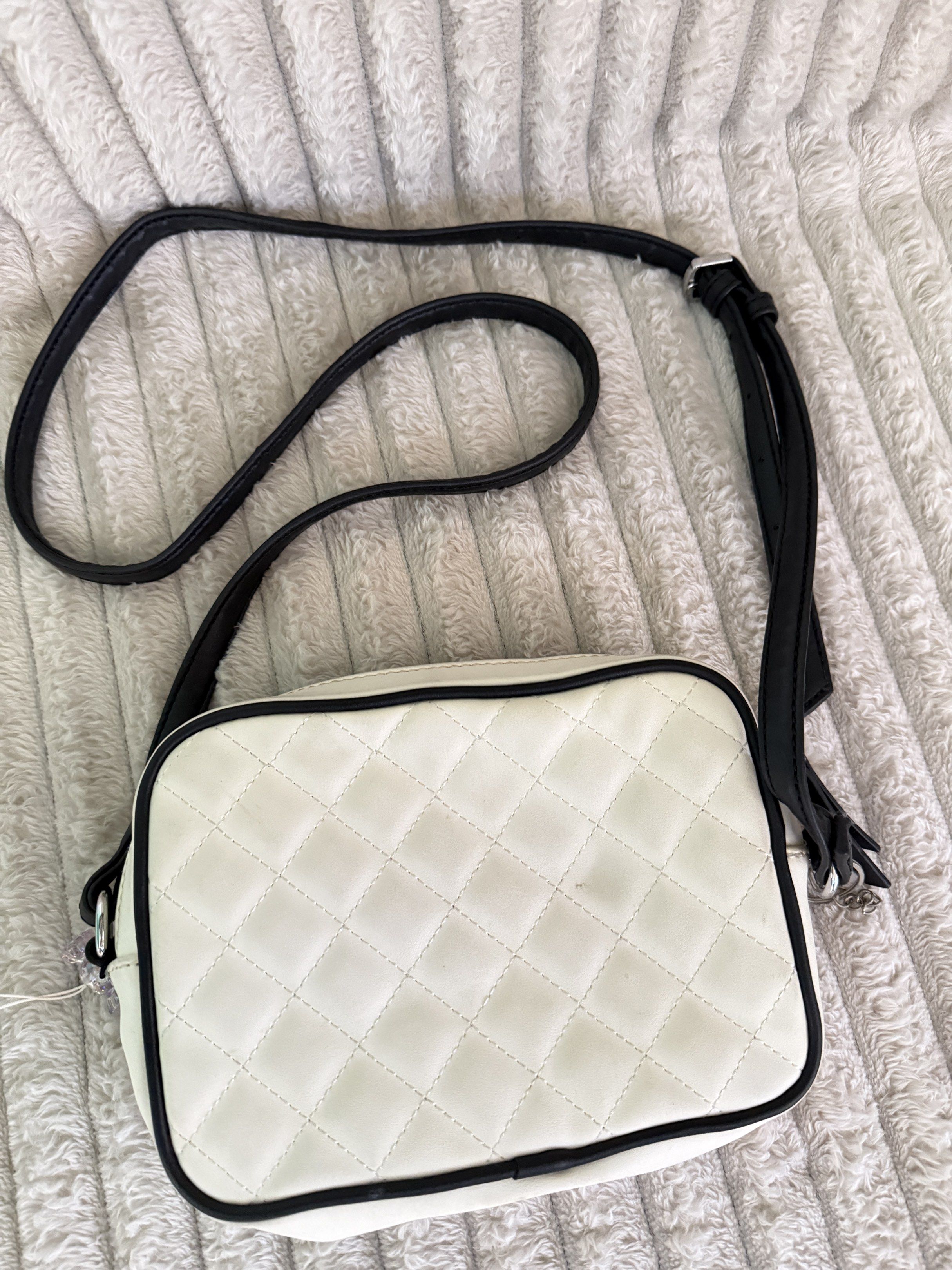 Nine West Quilted Crossbody Bag (Category: Cross-body Bags) located in Quezon City. Submitted by jcmelbs (Listing ID 1417706248, Image 2). Description: - Nine West crossbody bag - Quilted white exterior with black trim - Adjustable black strap - Zippered main compartment - Light-colored interior lining - Nine West label inside.