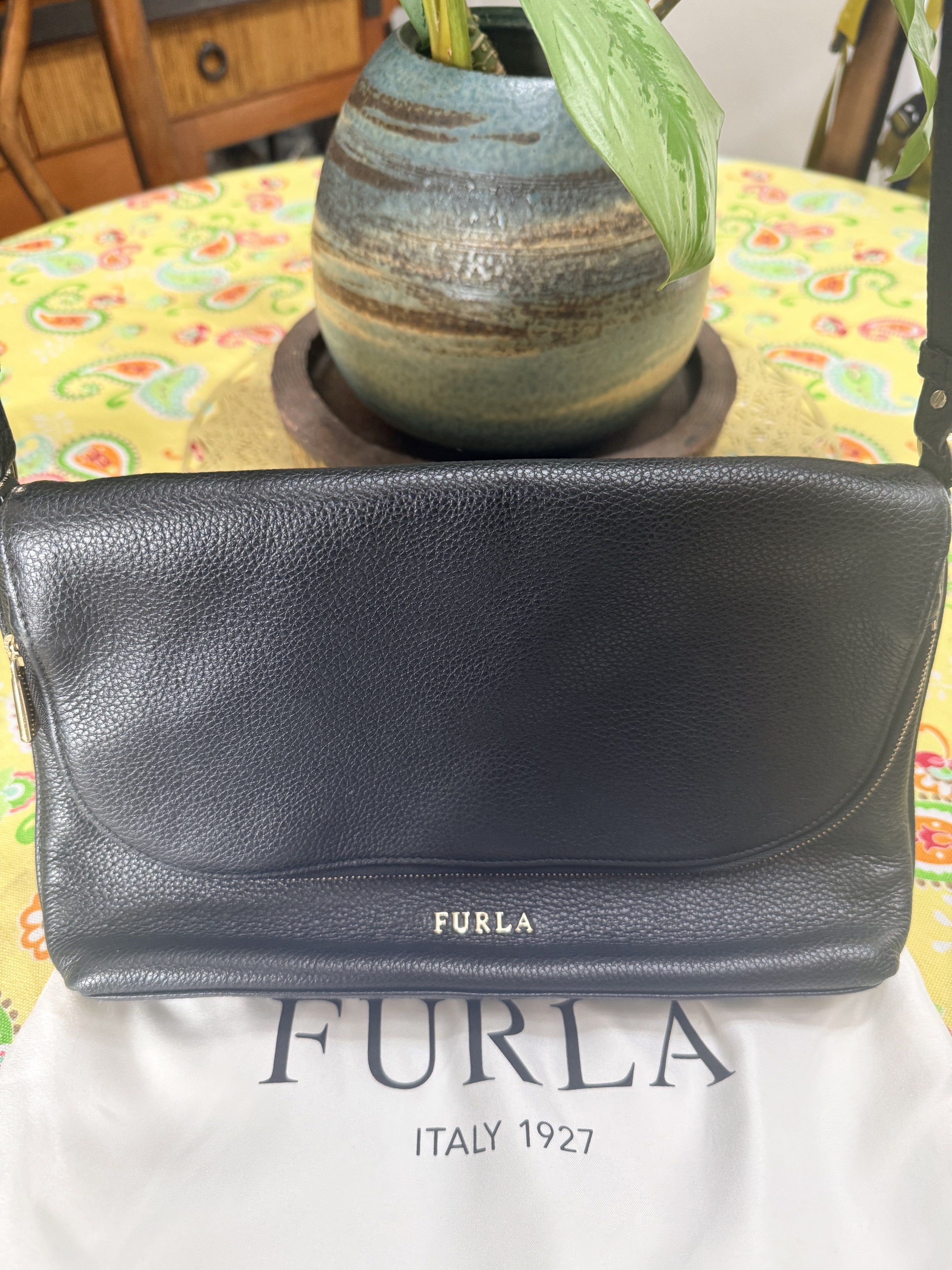 Original Furla Black Leather Shoulder Bag (Category: Luxury Bags & Wallets) located in Quezon City. Submitted by coco88. (Listing ID 1417665495, Image 2). Description: - Black Furla shoulder bag - Flap closure with magnetic snap - Adjustable shoulder strap - Main compartment and small interior pocket - Includes Furla dust bag - Textured leather exterior - Gold-tone Furla logo.