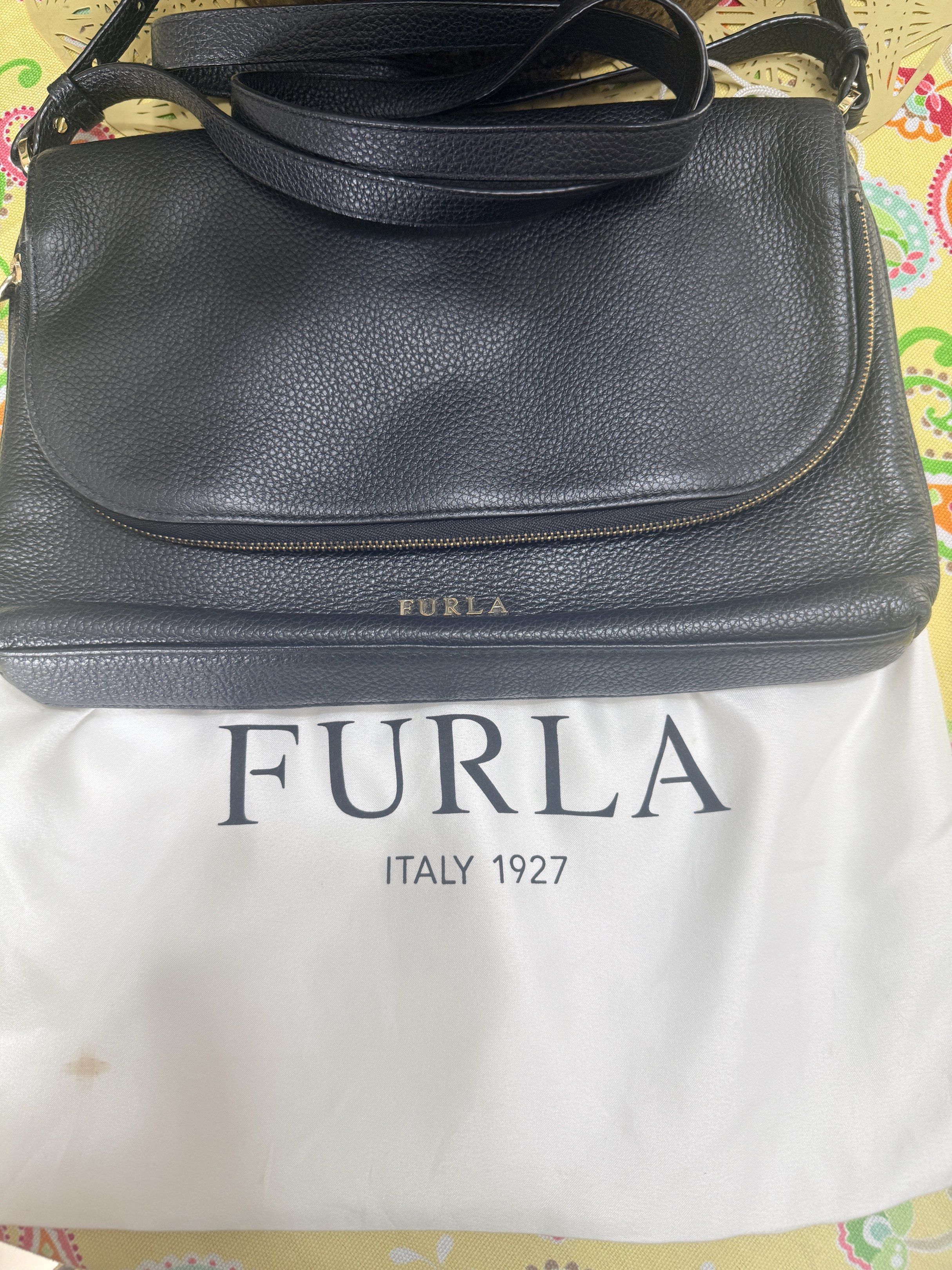 Original Furla Black Leather Shoulder Bag (Category: Luxury Bags & Wallets) located in Quezon City. Submitted by coco88. (Listing ID 1417665495, Image 1). Description: - Black Furla shoulder bag - Flap closure with magnetic snap - Adjustable shoulder strap - Main compartment and small interior pocket - Includes Furla dust bag - Textured leather exterior - Gold-tone Furla logo.