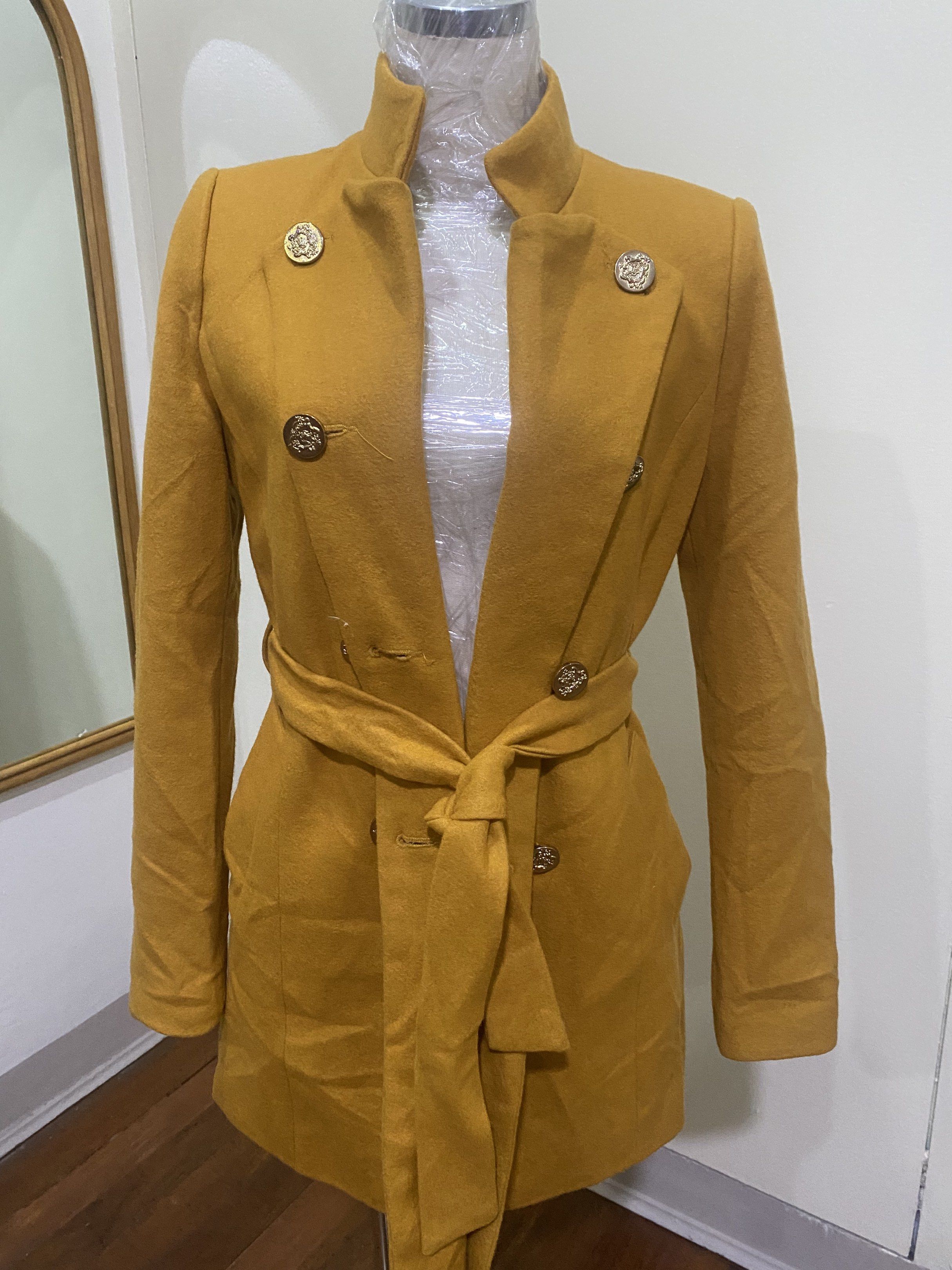 Ssemienne Korean Coat with Belt (Category: Coats, Jackets and Outerwear) located in Manila. Submitted by roseluxuryitems (Listing ID 1417726336, Image 2). Description: - Ssemienne mustard yellow coat - Size: S - Stand-up collar - Double-breasted with gold buttons - Includes matching belt - Quilted lining - Made in Korea.