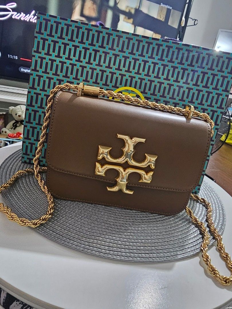 Tory Burch Eleanor Brown Leather Shoulder Bag (Category: Luxury Bags & Wallets) located in Pasig City. Submitted by Bananae_ (Listing ID 1417777813, Image 1). Description: - Tory Burch shoulder bag - Rich brown leather - Gold-tone chain strap - Iconic Tory Burch logo - Includes original paper bag and tags - Perfect for everyday or special occasions Size small Eleanor convertible sling bag Bought in December 2025 RFS: need funds.