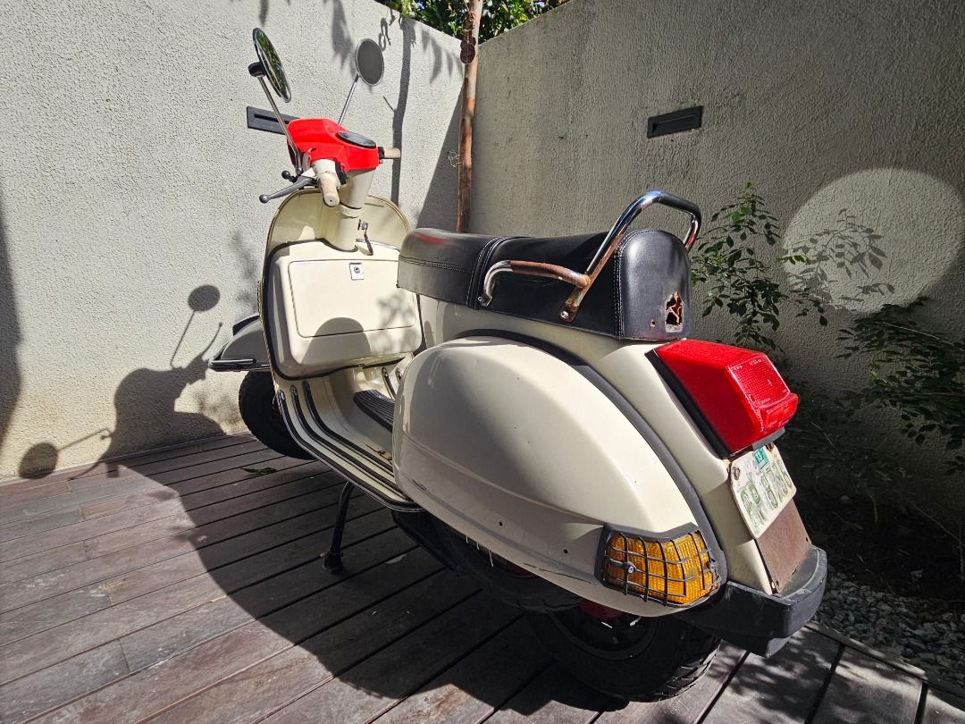 1997 Vespa PX150e (Italy) (Category: Other Motorcycles Parts and Accessories) located in Muntinlupa City. Submitted by inalostcarro (Listing ID 1417880382, Image 2). Description: NO TO SWAP 1997 Vespa PX150e With papers SIP tubeless tires Sito Plus Performance Exhaust Pipe Rebore piston New battery - Classic cream Vespa with red accents - Black seat - Chrome details - Includes spare tire - Headlight, side mirrors, and turn signals - Well-maintain