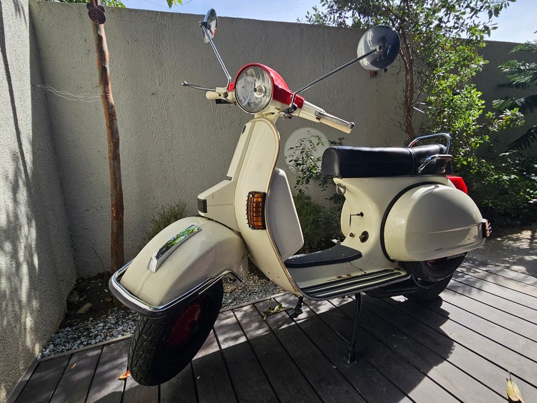 1997 Vespa PX150e (Italy) (Category: Other Motorcycles Parts and Accessories) located in Muntinlupa City. Submitted by inalostcarro (Listing ID 1417880382, Image 3). Description: NO TO SWAP 1997 Vespa PX150e With papers SIP tubeless tires Sito Plus Performance Exhaust Pipe Rebore piston New battery - Classic cream Vespa with red accents - Black seat - Chrome details - Includes spare tire - Headlight, side mirrors, and turn signals - Well-maintain