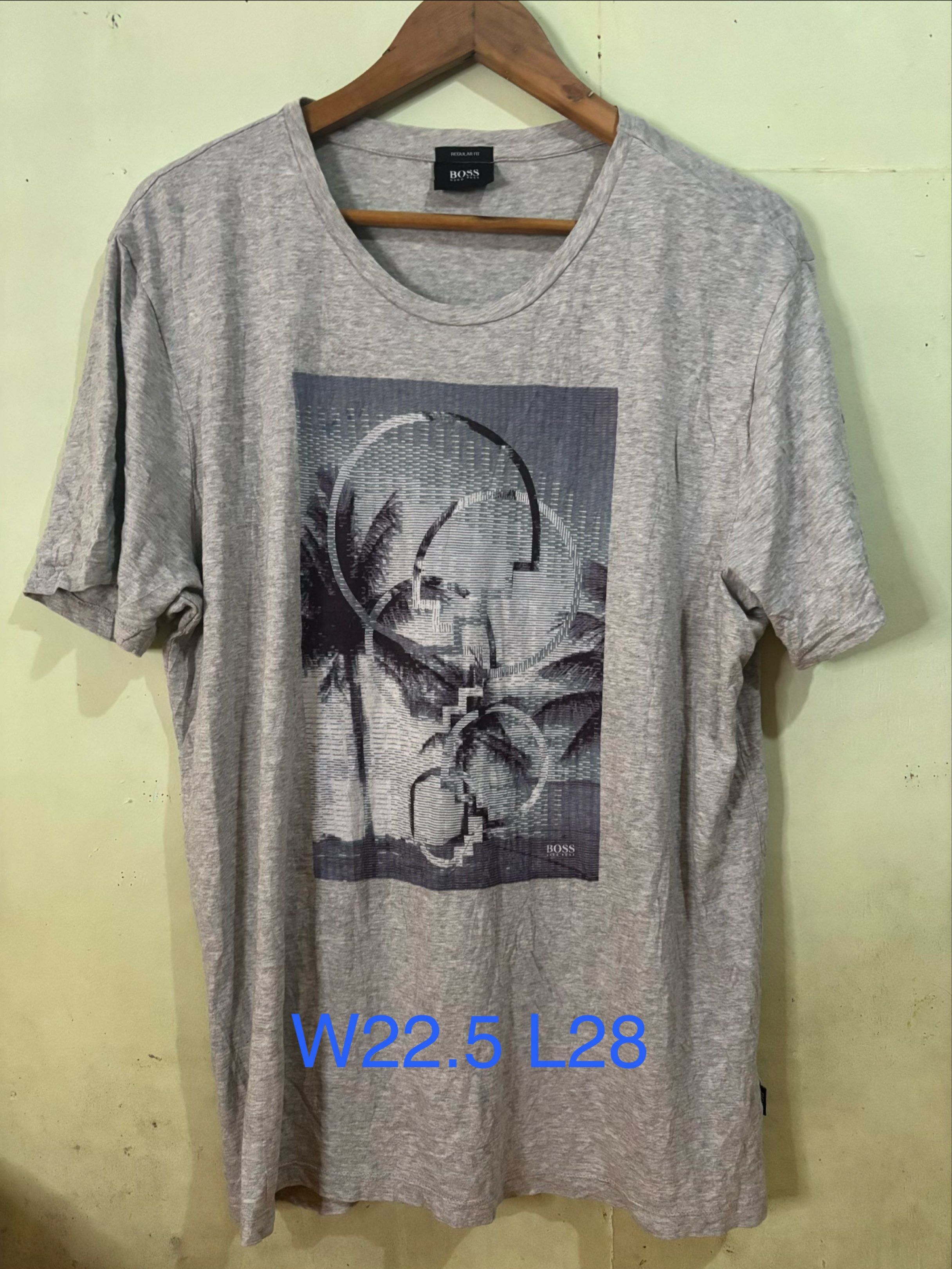 Authentic Hugo Boss Graphic Print T-Shirt (Category: Tshirts & Polo Shirts ) located in Tayabas. Submitted by mandothriftss (Listing ID 1417848743, Image 1). Description: Hugo Boss T-shirt in gray with a graphic print. Features a crew neck and short sleeves. The size is XXL. Measurements are W22.5 L28. Made of 100% cotton. Regular fit. Includes the Hugo Boss logo on the front and the tag..