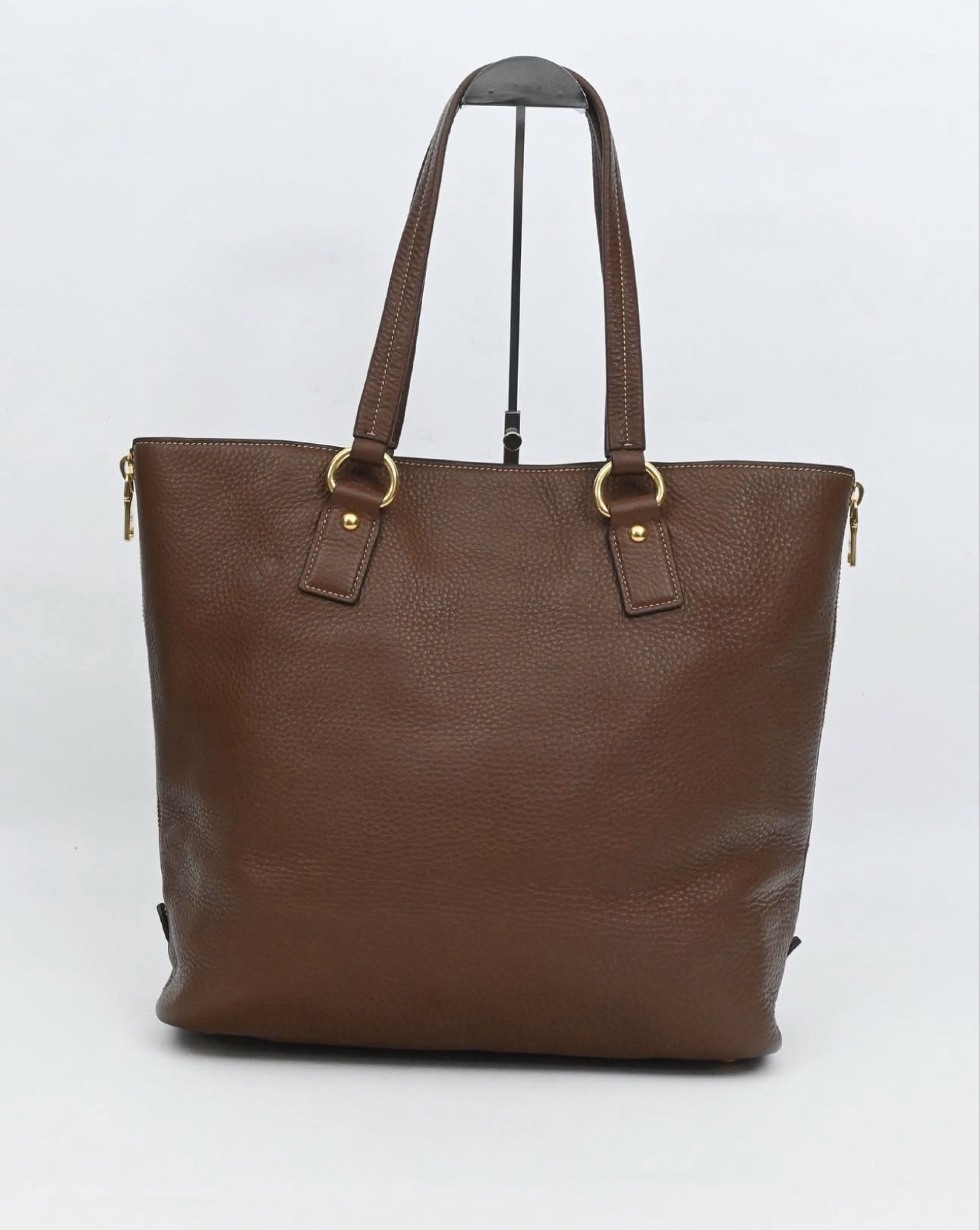 AUTHENTIC Prada Brown Leather Tote Bag (Category: Luxury Bags & Wallets) located in Manila. Submitted by itsmecamieeee (Listing ID 1417988117, Image 2). Description: - Authentic Prada tote bag - Brown leather exterior (Smooth and no cracks) - Gold-tone hardware (Hardware still goldish) - Zip closure (Still goldish) - Structured shape with flat base - Prada-branded interior lining - Detachable leather tag - Includes dust bag - No flaws - Negotiabl