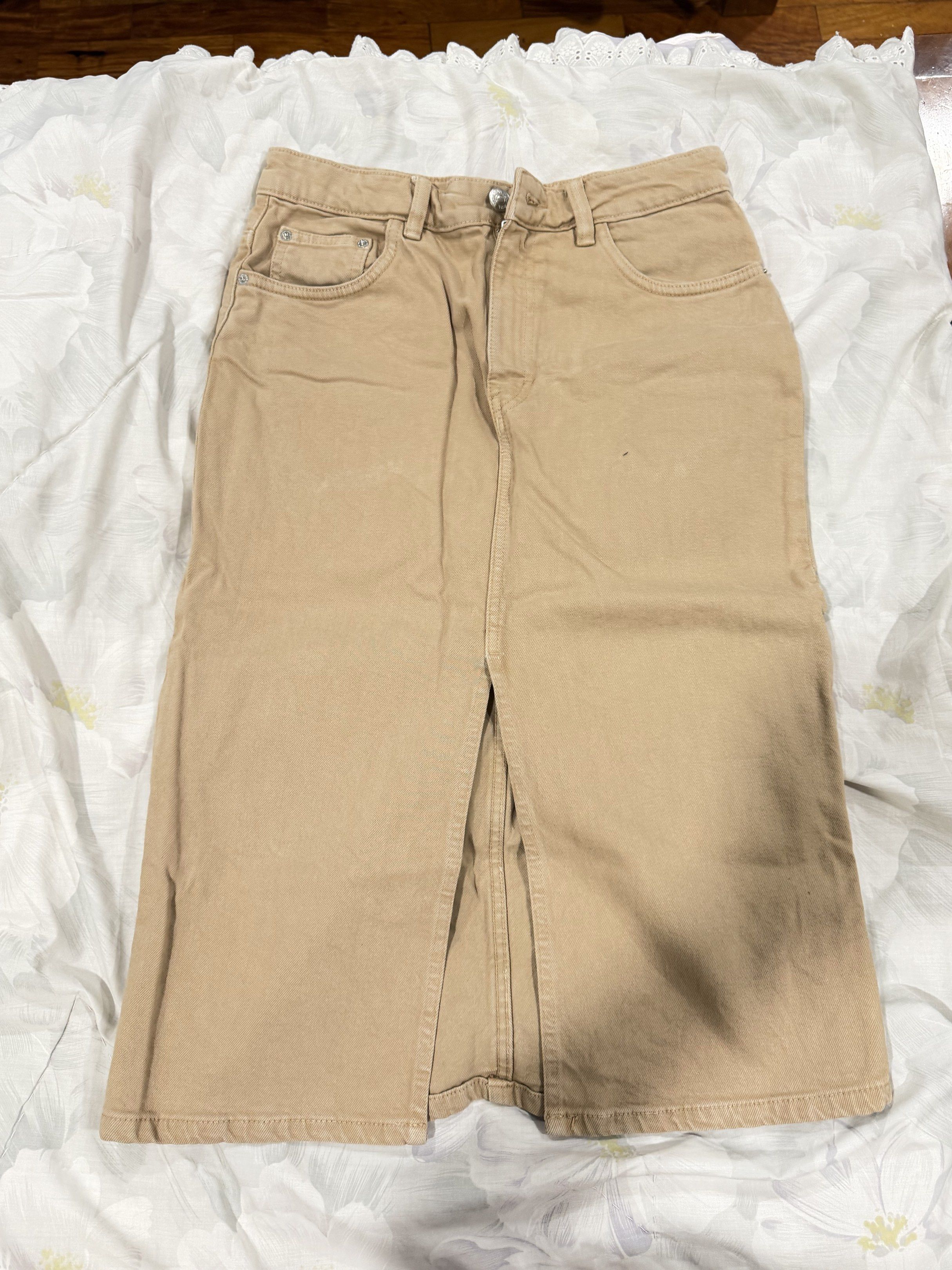 Brown/Beige Denim Midi Skirt (Category: Skirts) located in Del Monte. Submitted by bren.lim (Listing ID 1417976324, Image 1). Description: - Beige denim midi skirt - Front slit detail - Button and zipper closure - Front and back pockets - Sturdy denim material - High-waisted design - Ideal for casual outfits.