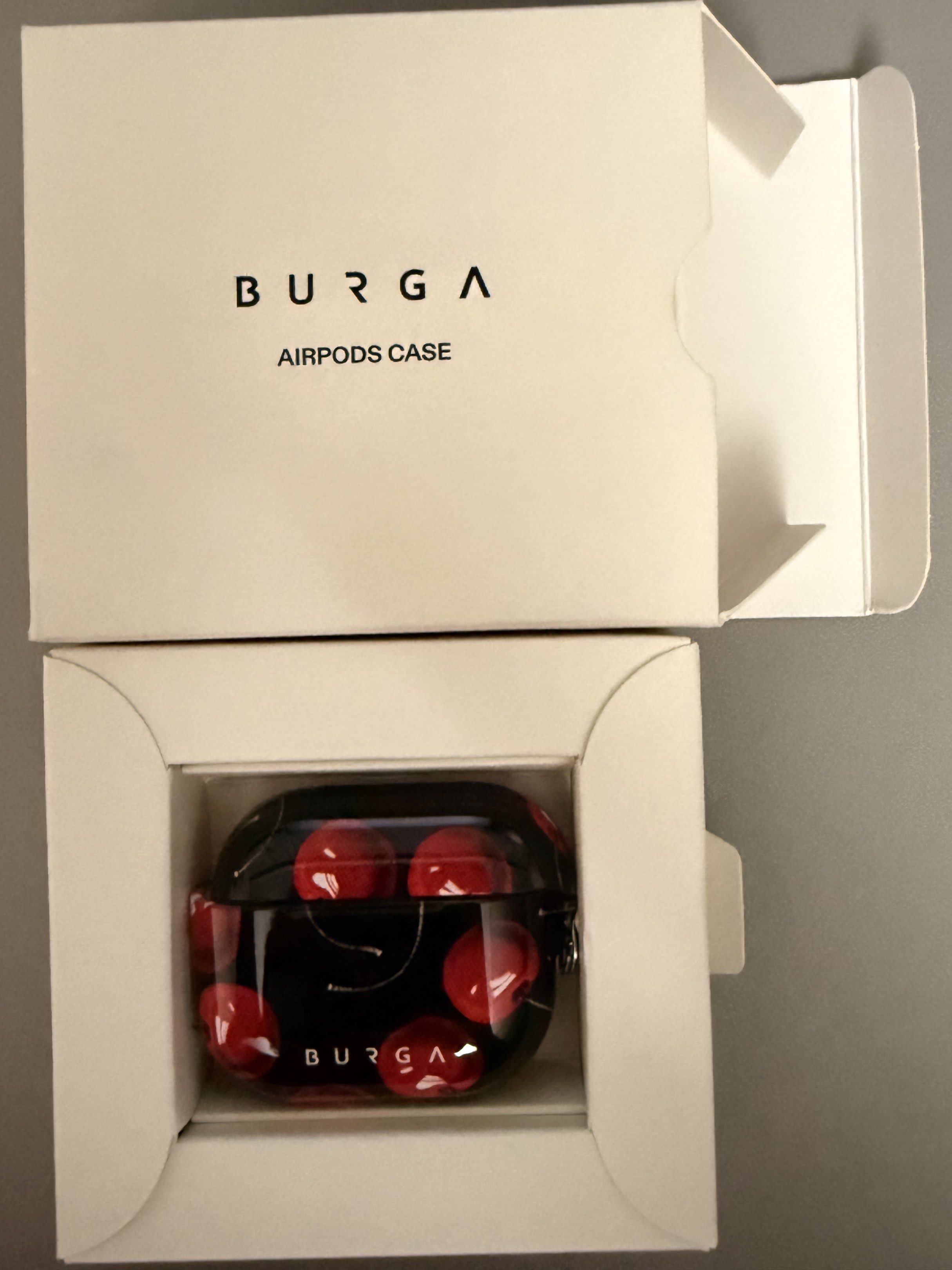 Original Burga AirPods Case - Cherry Design (Category: Cases & Sleeves) located in Antipolo. Submitted by maeria (Listing ID 1417959755, Image 2). Description: Burga AirPods case features a vibrant cherry design. It is designed for AirPods and includes a keychain attachment. The case offers 360° drop protection, supports wired and wireless charging, and has a scratch-resistant finish. It comes in its original packaging. RFS: Wrong Case.