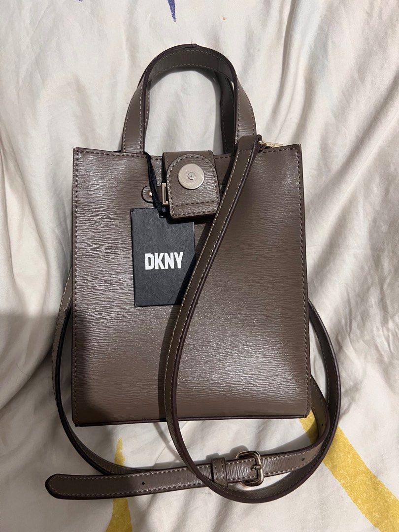 DKNY Alison Small Tote Bag (Category: Luxury Bags & Wallets) located in Santa Rosa. Submitted by sweetsillystuff (Listing ID 1417914265, Image 3). Description: - DKNY Alison Small Tote Bag - Neutral color - Top handle and detachable shoulder strap - Magnetic closure - Interior pocket - Brand new with original tag - MSRP: "$158.00" - DKNY logo on the front.