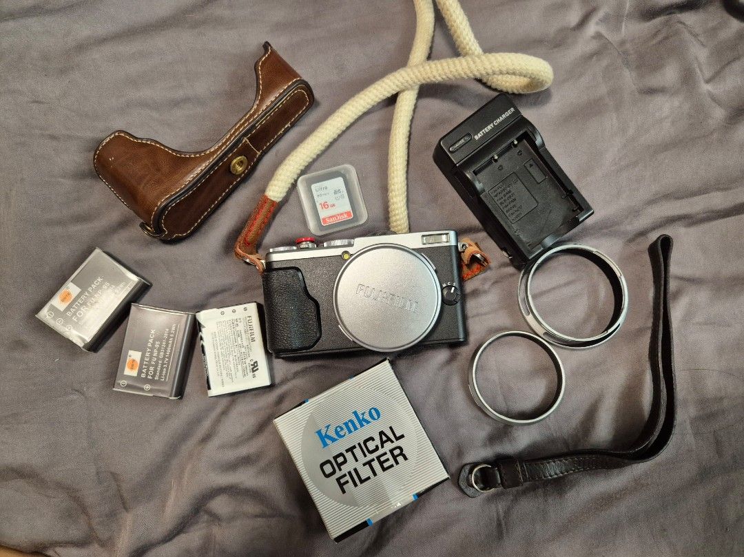 Fujifilm X70 Digital Camera (Category: Cameras) located in Las Pinas. Submitted by katdideles (Listing ID 1417828587, Image 1). Description: - Fujifilm X70 digital camera - Silver body with black grip - Includes: - Camera half case case - Kenko optical filter - Wall Charger - Strap - SD card (2pcs 64gig and 16gig) - 3 batteries - No box RFS: hardly using this anymore Issues / notes: Camera has a scratched screen protector but no issue with the ac