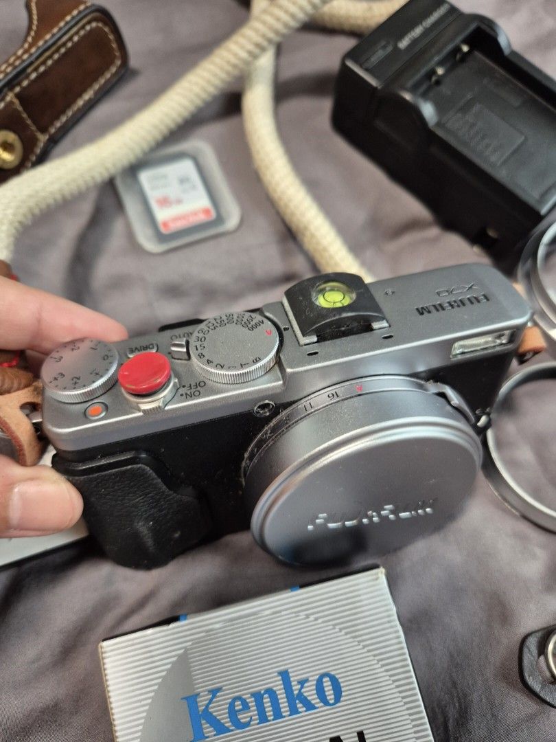 Fujifilm X70 Digital Camera (Category: Cameras) located in Las Pinas. Submitted by katdideles (Listing ID 1417828587, Image 2). Description: - Fujifilm X70 digital camera - Silver body with black grip - Includes: - Camera half case case - Kenko optical filter - Wall Charger - Strap - SD card (2pcs 64gig and 16gig) - 3 batteries - No box RFS: hardly using this anymore Issues / notes: Camera has a scratched screen protector but no issue with the ac