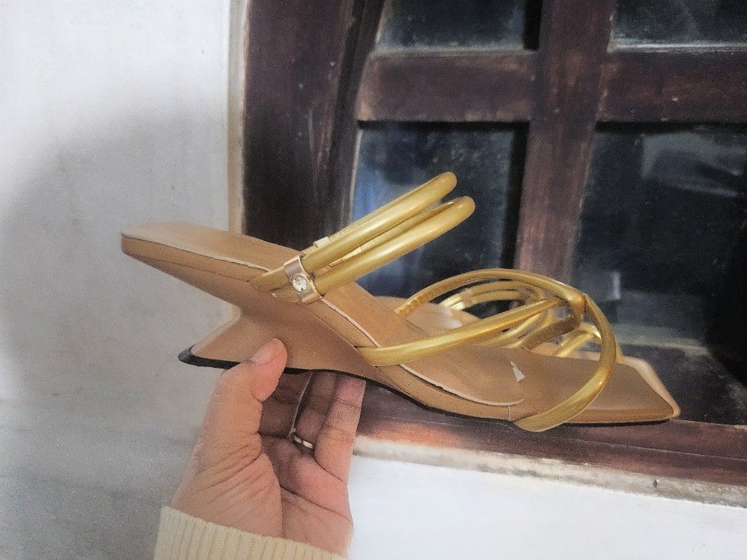 Gold Strappy Heels (Category: Heels) located in Manila. Submitted by honeypatch (Listing ID 1417959155, Image 2). Description: Elegant gold strappy heels with a unique heel design. Features a square toe and multiple straps for a secure fit. The sandals have a light brown footbed. Perfect for special occasions or adding a touch of glamour to any outfit. .
