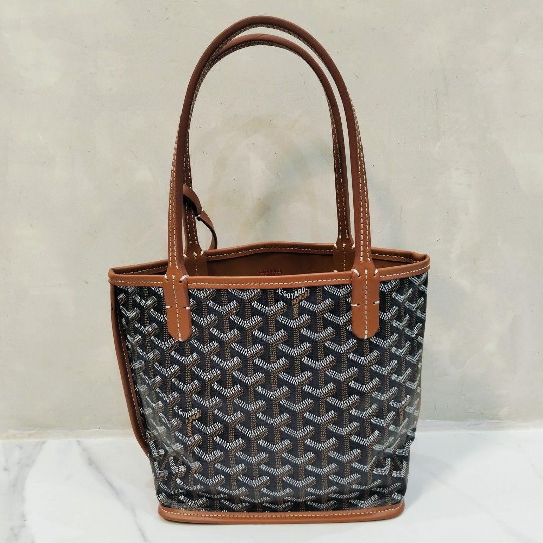 Goyard Mini Tote Bag with Pouch (Category: Luxury Bags & Wallets) located in Dagupan City. Submitted by youngthrift_ (Listing ID 1417847329, Image 2). Description: Goyard mini tote bag with matching pouch. Features the signature Goyardine pattern in black and brown. The bag has brown leather trim and handles with white stitching. The pouch has a snap closure and is stamped with "Goyard Paris Made in France". The interior of the bag is brown leath
