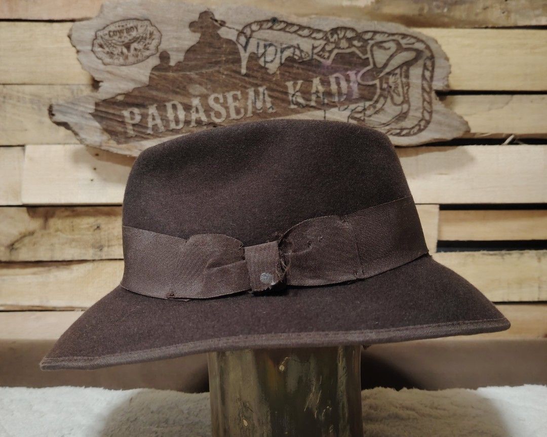 Indiana Jones Fedora Hat (Category: Caps & Hats) located in La Trinidad. Submitted by padasem_kadi (Listing ID 1417829574, Image 3). Description: - Classic brown fedora hat - Features a stylish ribbon band - Interior lining with "Indiana Jones" branding - Made from a felt-like material - Subtle curved brim - Includes a decorative bow detail.