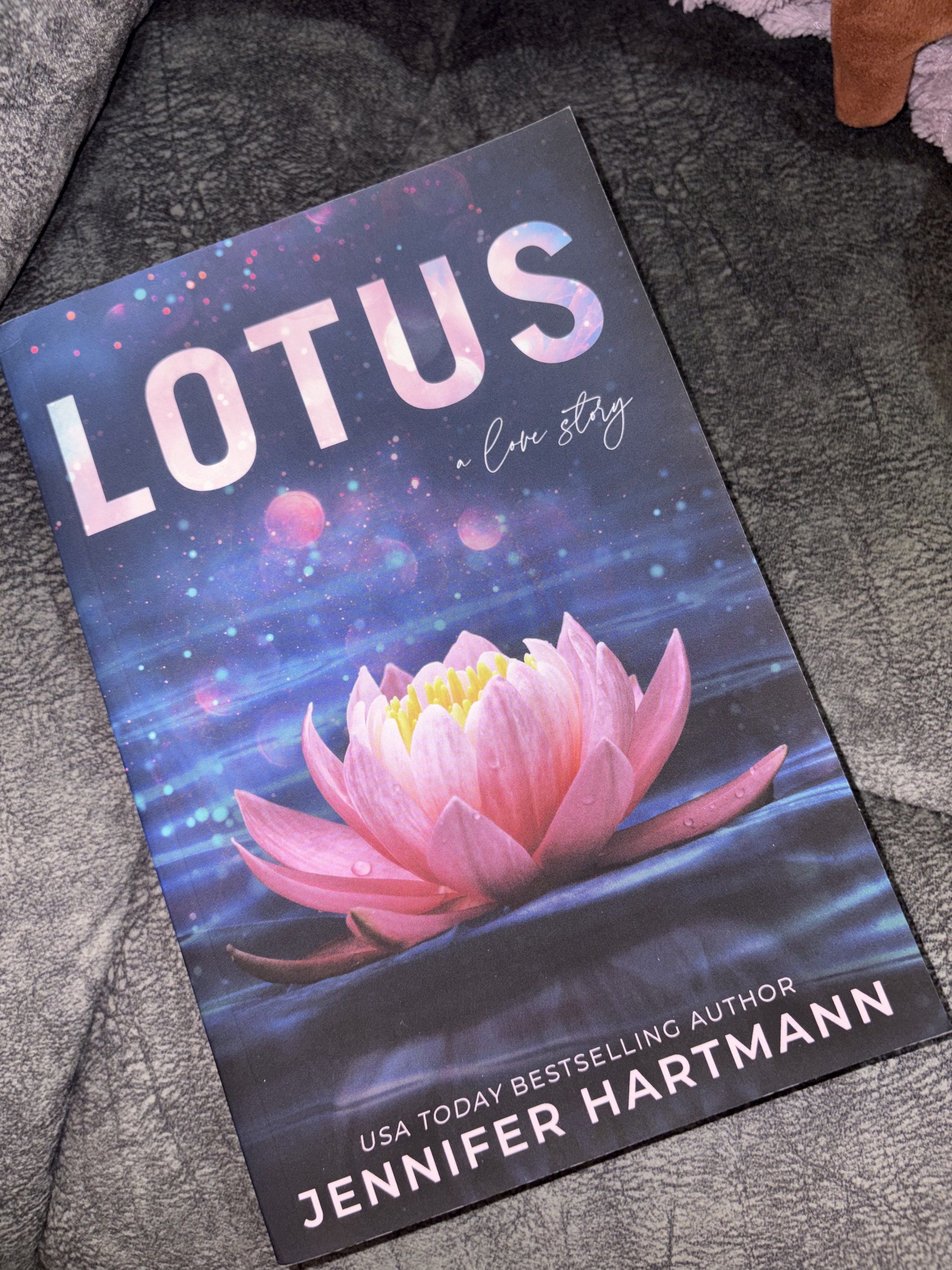 Lotus by Jennifer Hartmann US PB (Category: Storybooks) located in Naic. Submitted by stabarding (Listing ID 1418010739, Image 1). Description: - Title: Lotus by Jennifer Hartmann - Genre: Love Story - Publisher: bloombooks - Cover: Features a pink lotus flower - Back: Includes a story summary - Condition: Minor tear on the top of the spine.