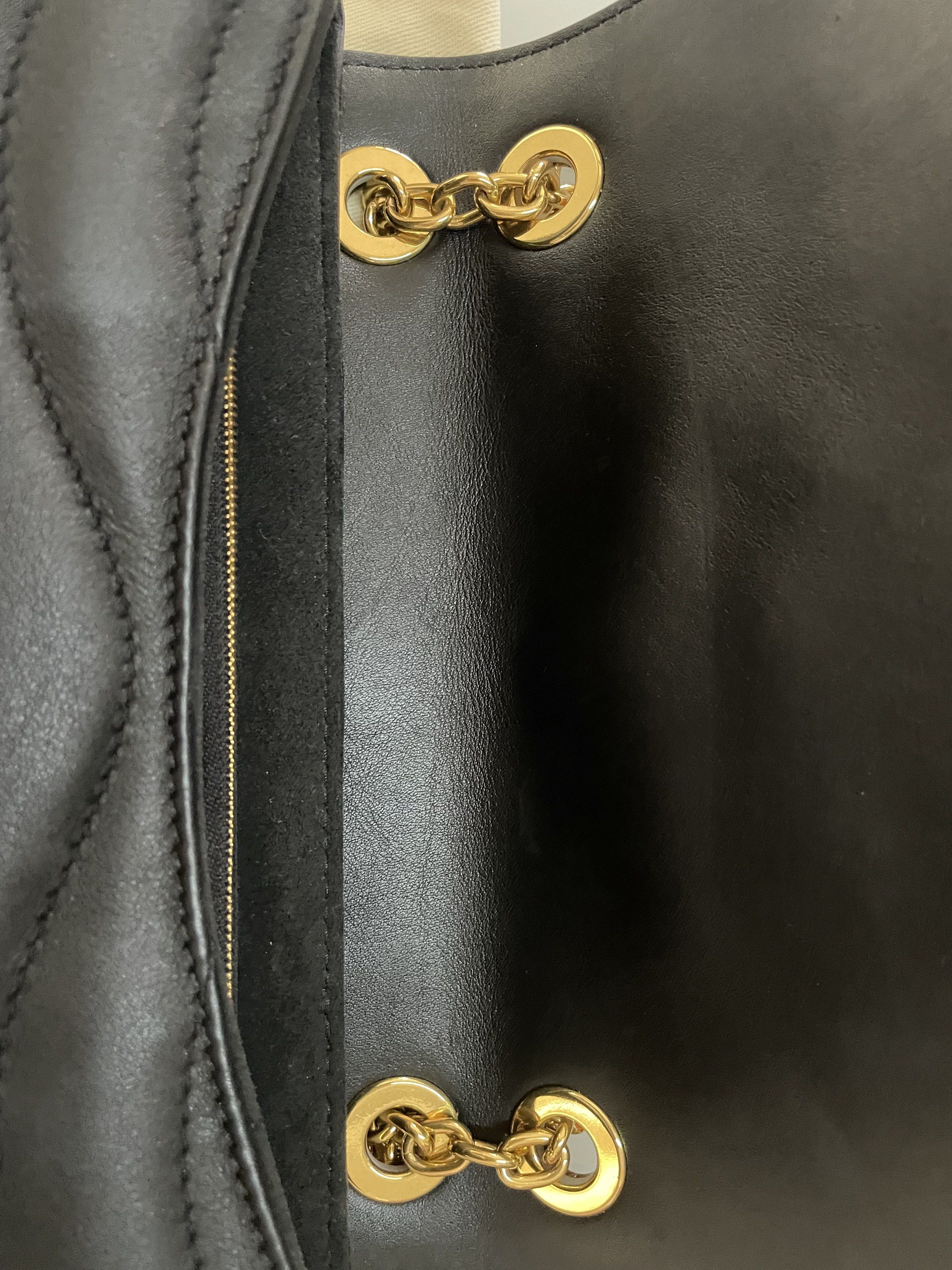 Louis Vuitton New Wave Chain Bag Black (Category: Luxury Bags & Wallets) located in Taguig. Submitted by declutteringmom314 (Listing ID 1417864752, Image 3). Description: Authentic Louis Vuitton New Wave Chain Bag in black. Features a quilted design with a gold-tone LV logo on the front. Includes a chain strap with a leather shoulder rest. Comes with original box, dust bag, and shopping bag. The interior has a zip pocket. The zipper pull has the 