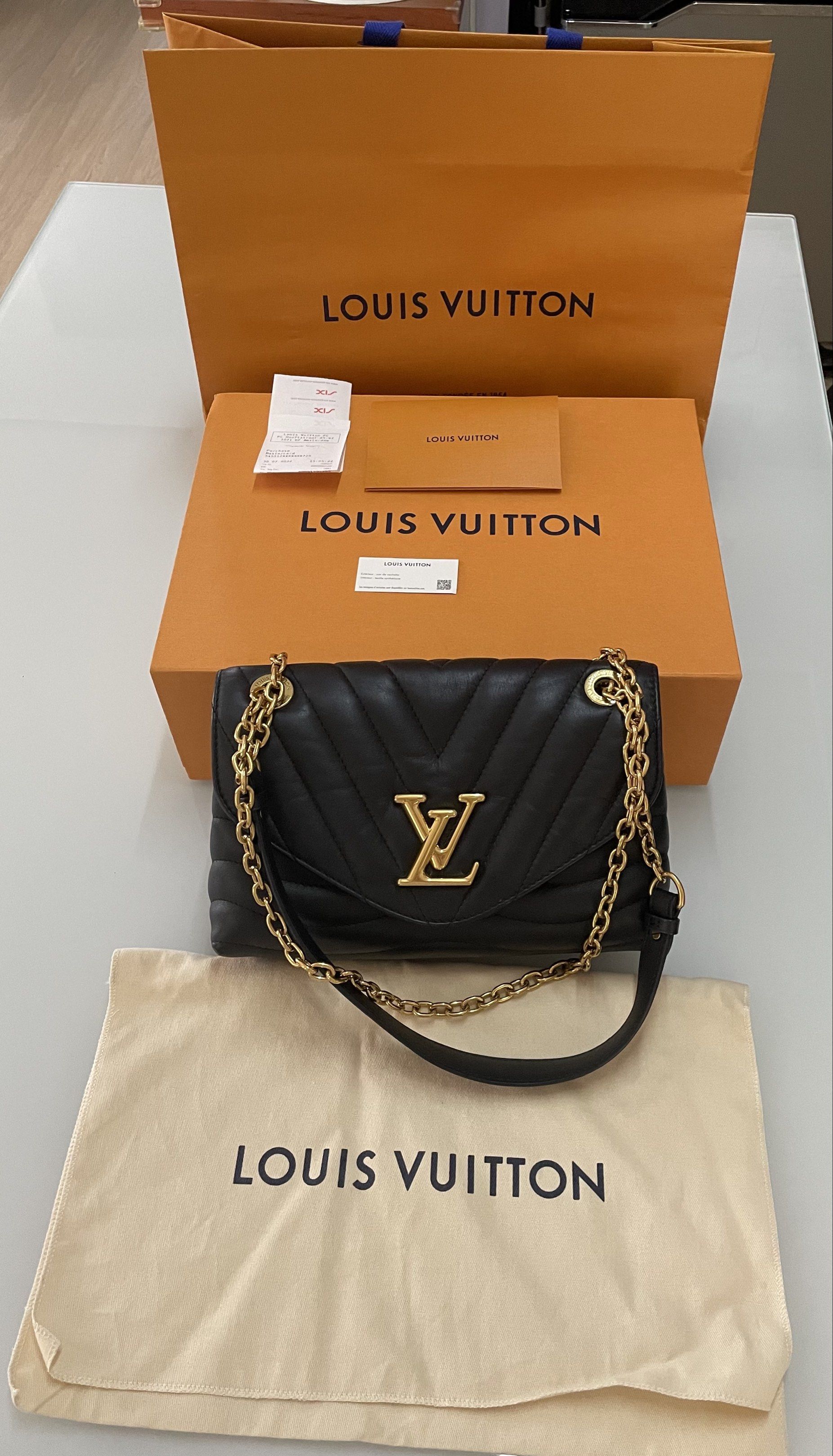 Louis Vuitton New Wave Chain Bag Black (Category: Luxury Bags & Wallets) located in Taguig. Submitted by declutteringmom314 (Listing ID 1417864752, Image 1). Description: Authentic Louis Vuitton New Wave Chain Bag in black. Features a quilted design with a gold-tone LV logo on the front. Includes a chain strap with a leather shoulder rest. Comes with original box, dust bag, and shopping bag. The interior has a zip pocket. The zipper pull has the 