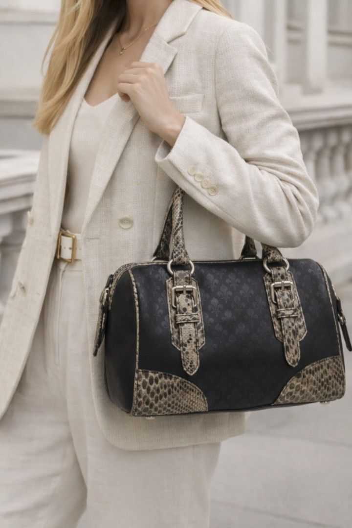 Patrick Cox Leather Snake Doctors Bag (Category: Luxury Bags & Wallets) located in Baguio. Submitted by PreiLoveMaria (Listing ID 1417973208, Image 1). Description: Patrick Cox handbag featuring the brand's signature fleur-de-lys (lily crest) logo pattern. The bag is a black satchel style with faux snakeskin accents on the handles, buckles, and bottom corners. 👜Good used condition with minimal flaw (needs stiching in the zipper about an inch. Pl