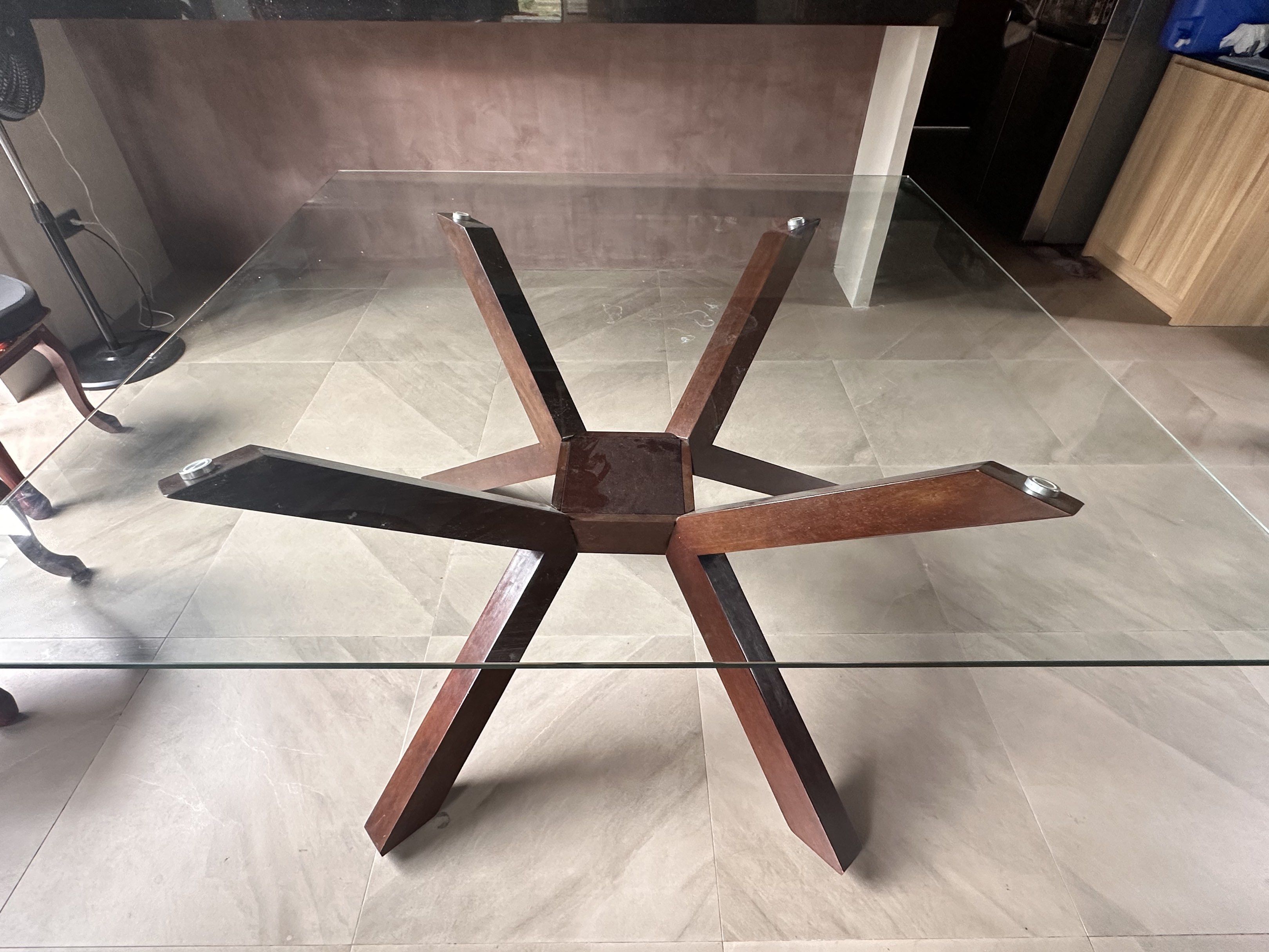 Square Glass Dining Table (1.5m Solid Wood Base) (Category: Tables & Sets) located in Cabuyao City. Submitted by knxtrnl_ (Listing ID 1417896792, Image 3). Description: Dimensions: 150cm x 150cm (Square) • Height: Standard Dining Height (~75-76cm) • Top: Thick Tempered Glass (Clear, Heavy Duty) • Base: Solid Wood Architectural “Star” Base (Dark Walnut Finish) Comfortably seats 8 people (2 on each side) Bought from CW Home Depot but it’s too big f